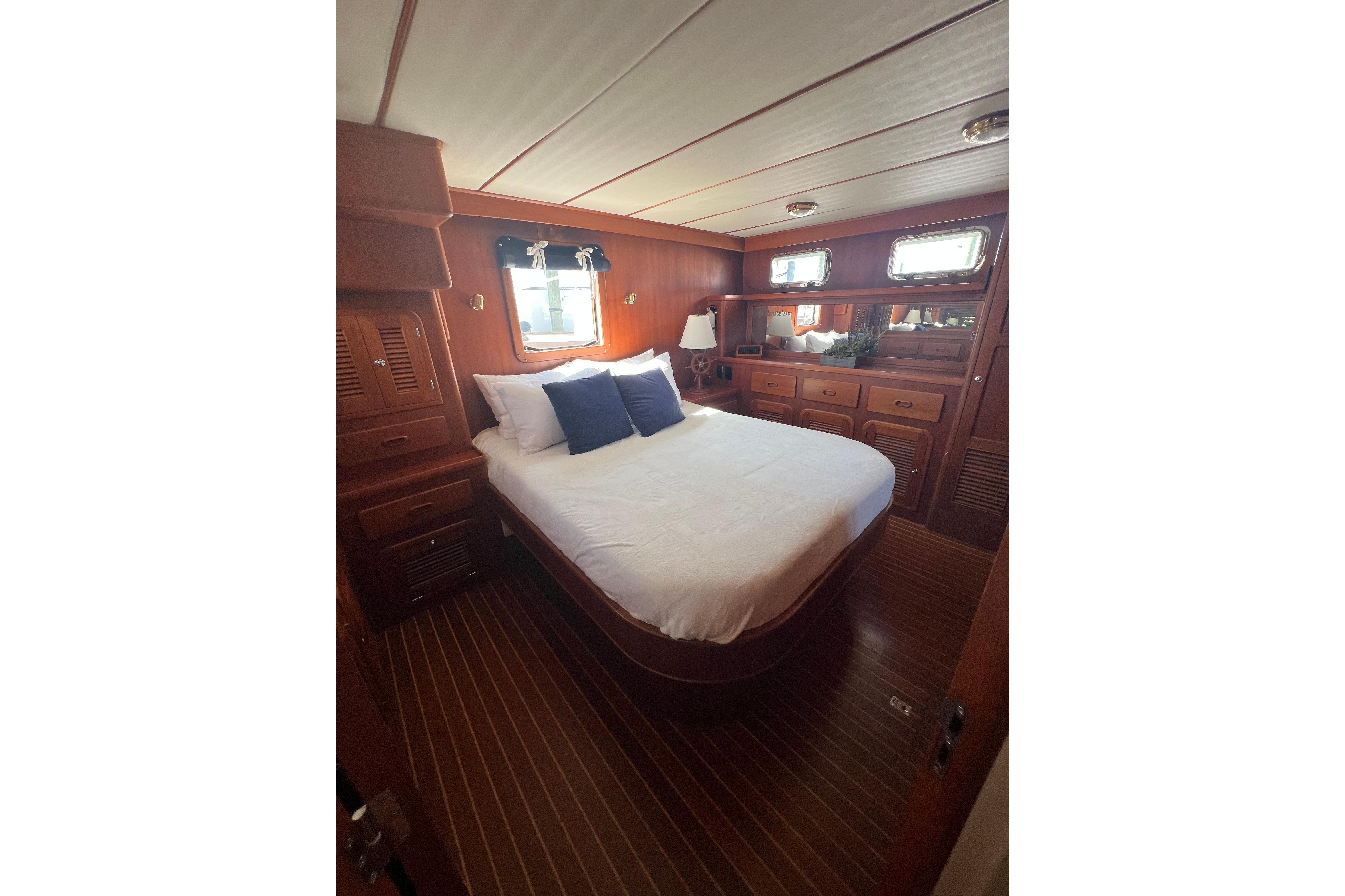 Luxurious bedroom interior of 2007 Heritage East 36 Sundeck Trawler with wood finish.