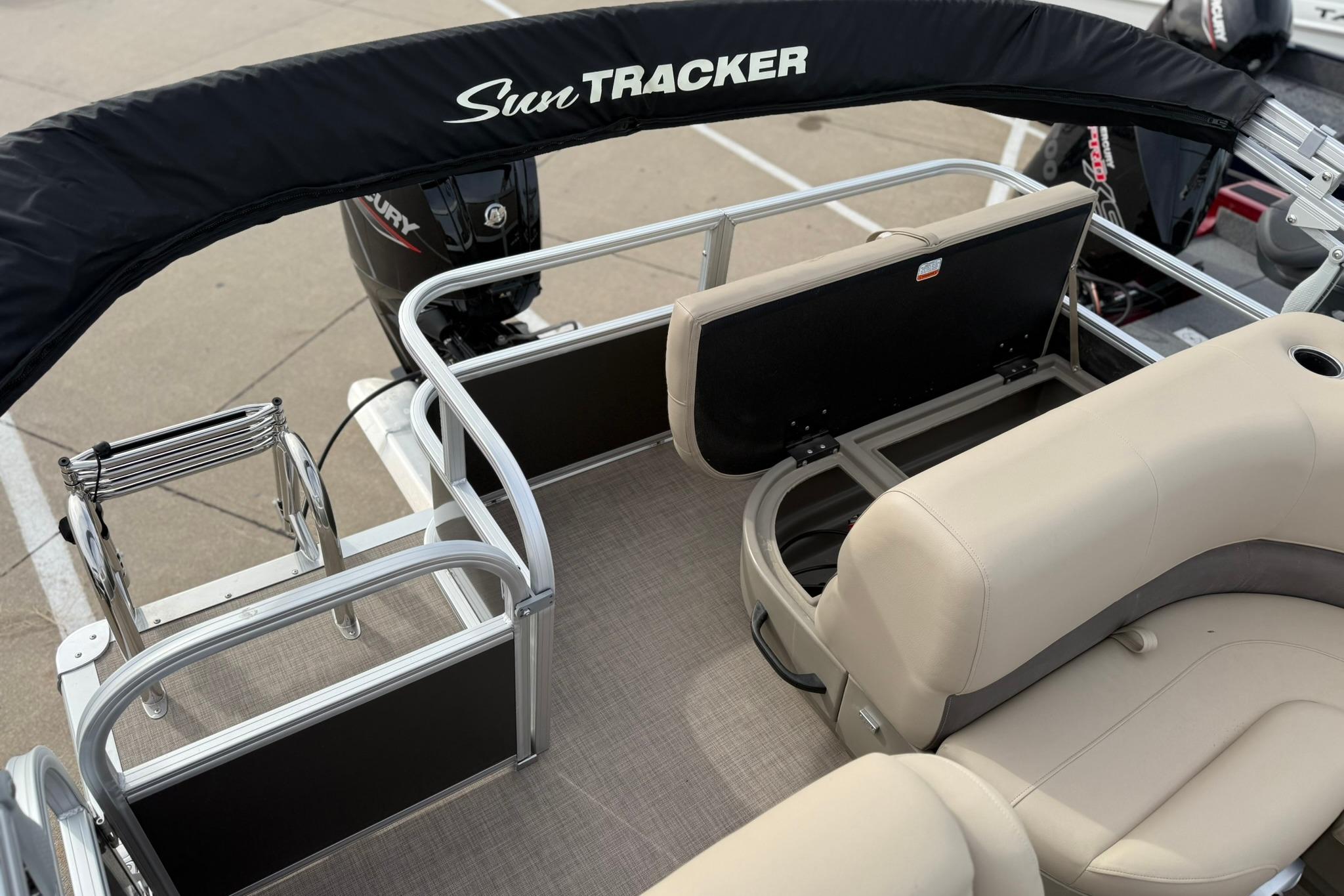 2025 Sun Tracker Party Barge 18 DLX with beige seating and storage, featuring a Mercury engine.