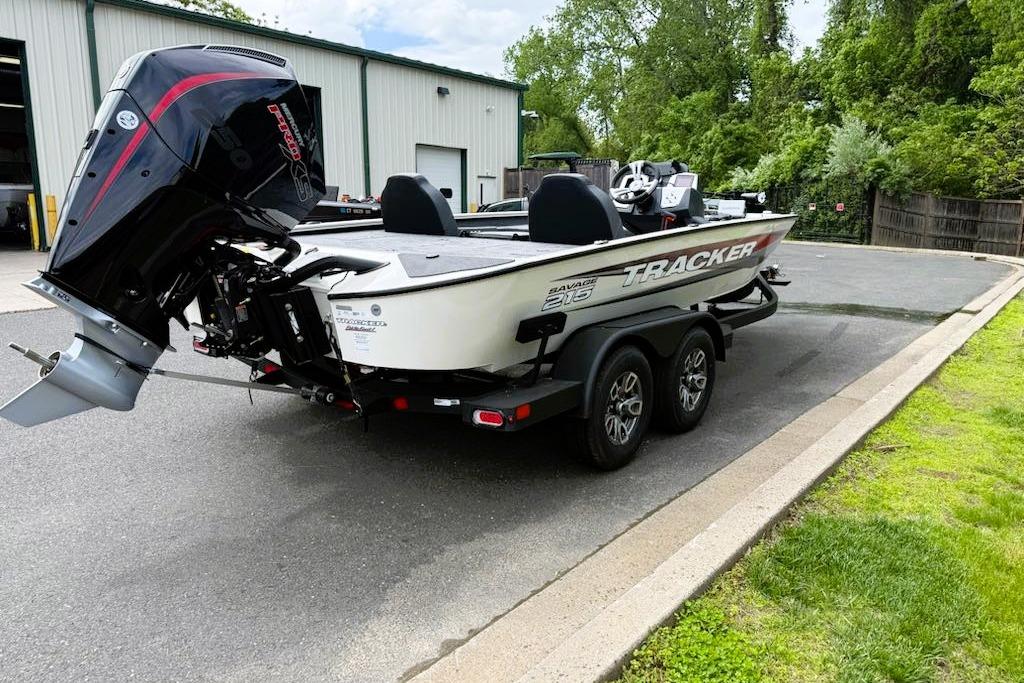 2025 Tracker Savage 215 boat on trailer, parked outdoors near a building.