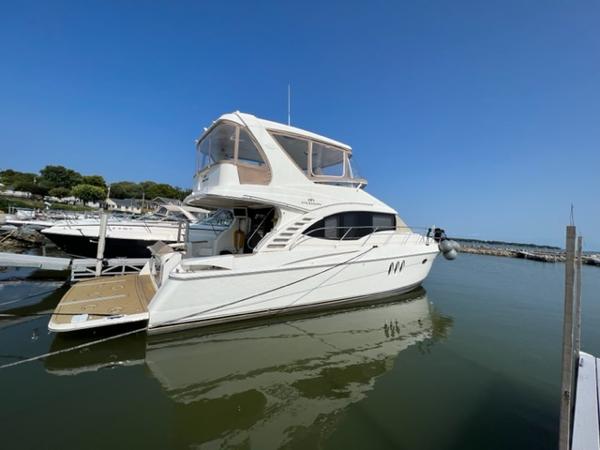 2009 Ovation 52 yacht docked at a marina on a sunny day.