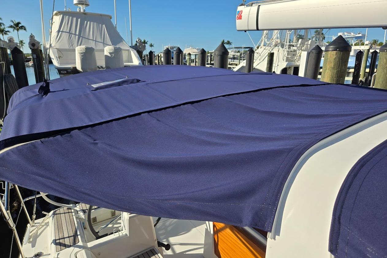 2023 Beneteau Oceanis 38.1 sailboat with blue canvas cover docked at marina.