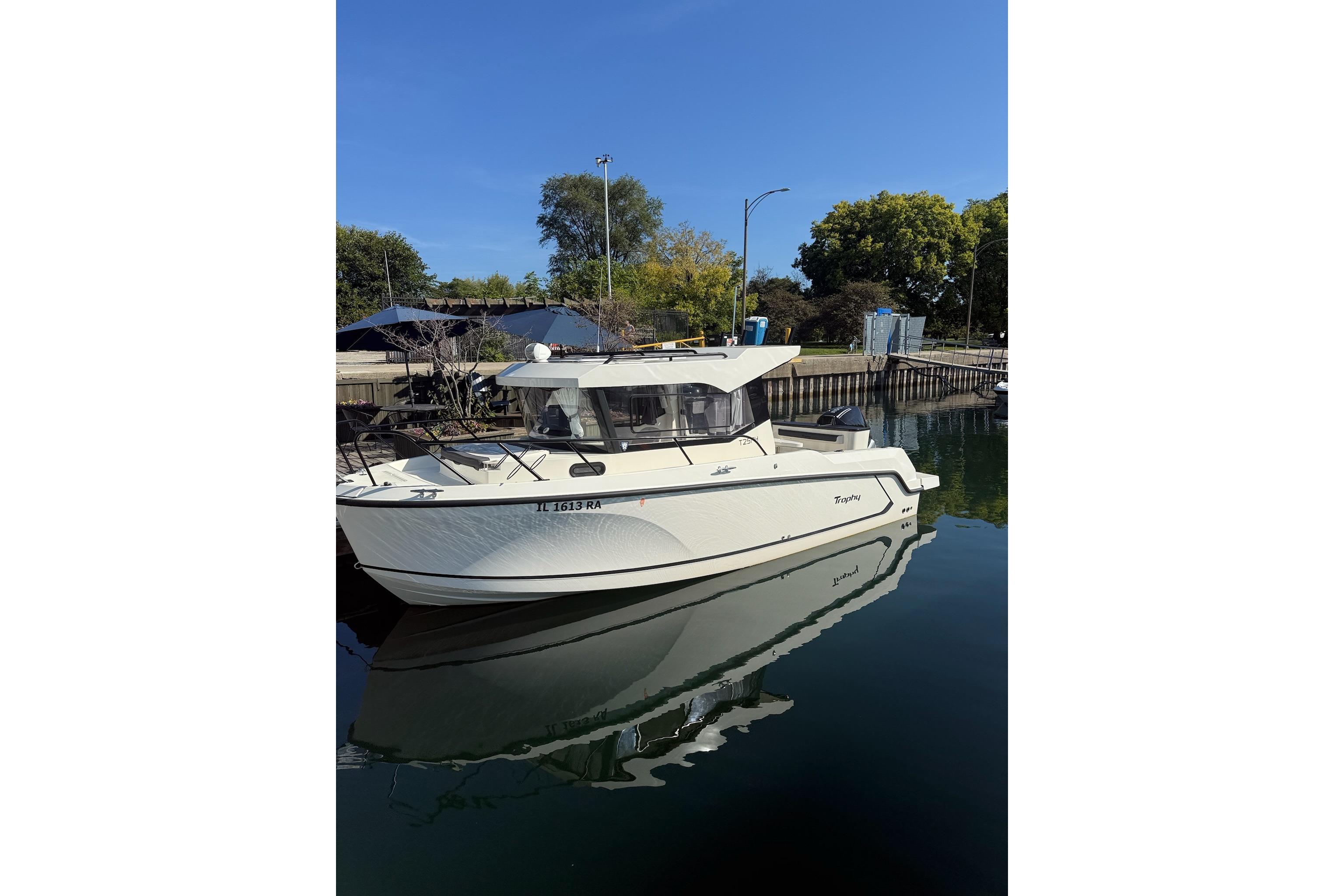 2024 Bayliner Trophy T25 Pilothouse boat docked on calm water.