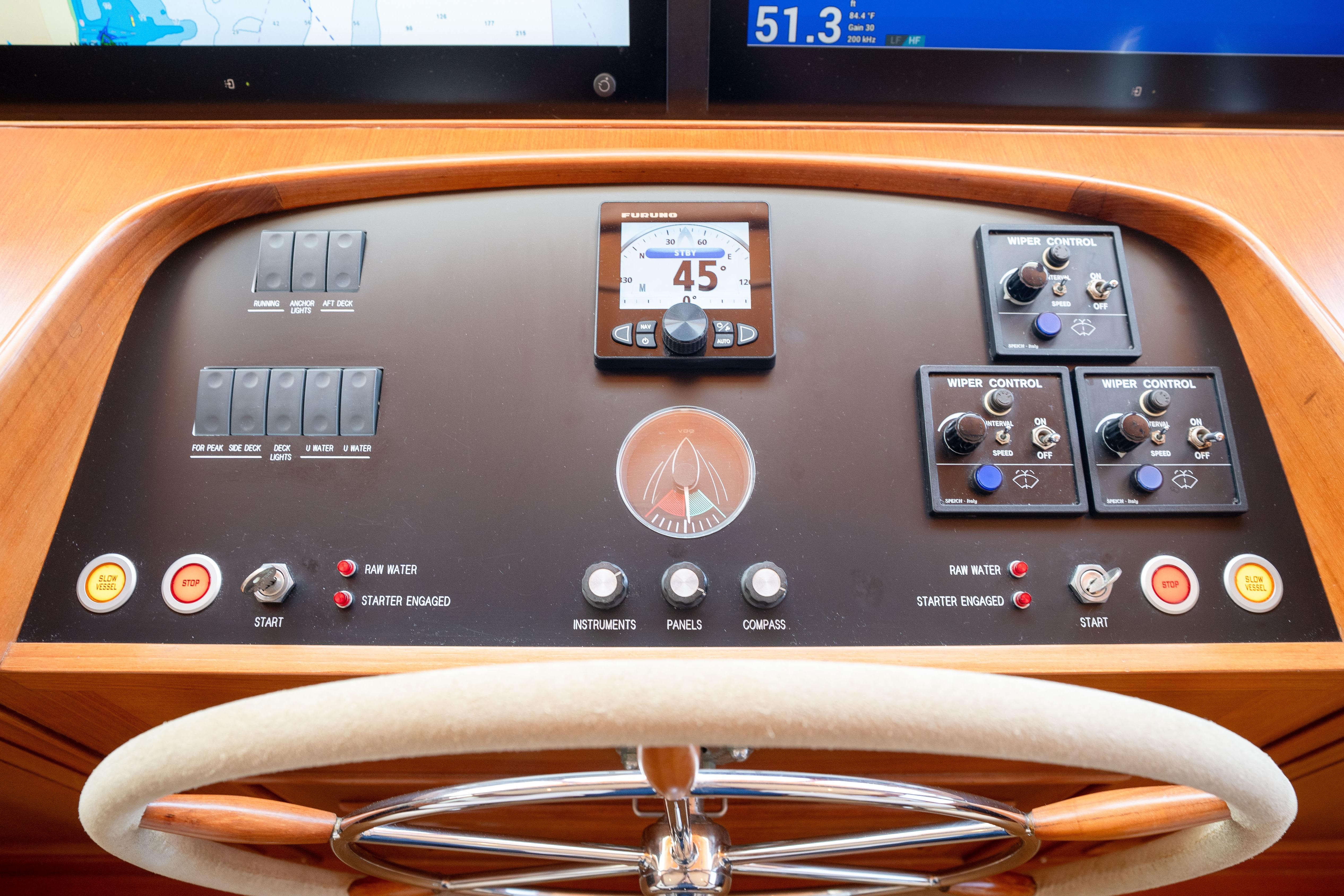 Helm controls of a 2006 Fleming 75 yacht with navigation instruments and steering wheel.