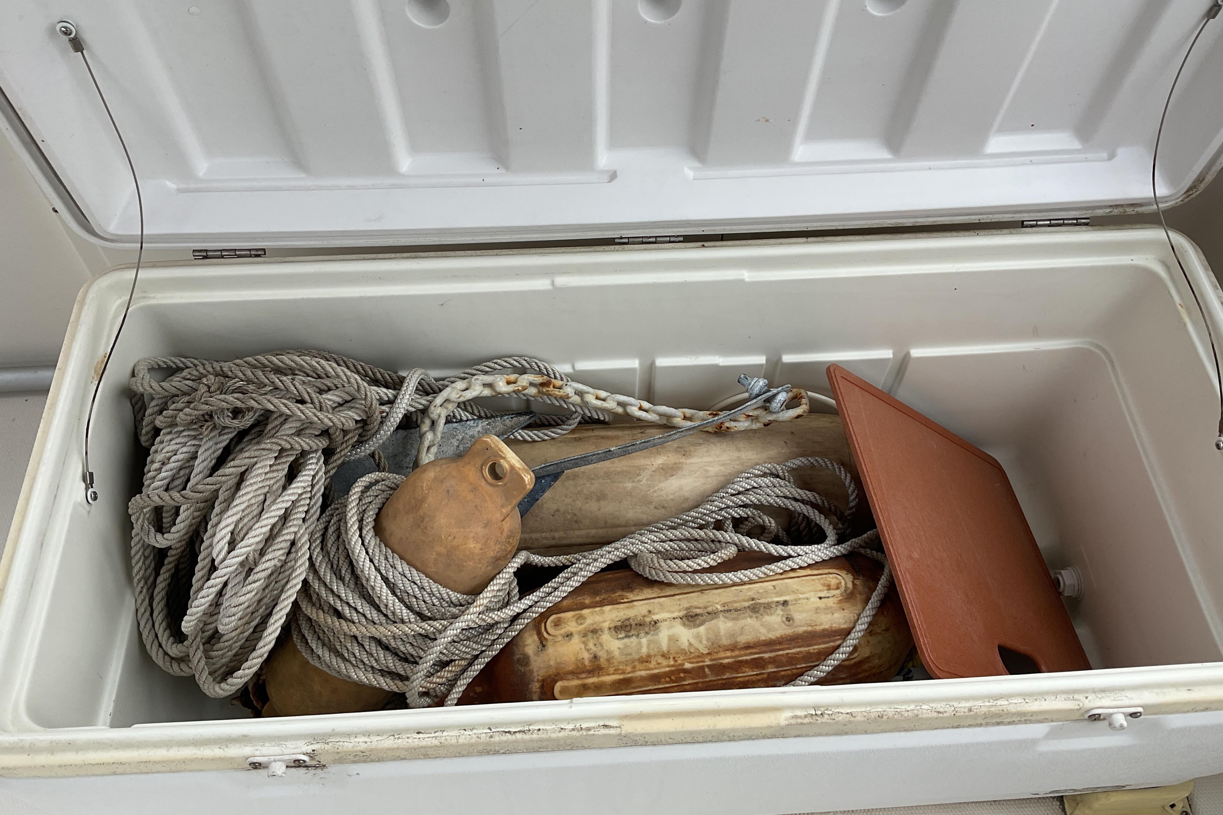 Open storage compartment on 2012 Wellcraft 232 Coastal boat with ropes and buoys.