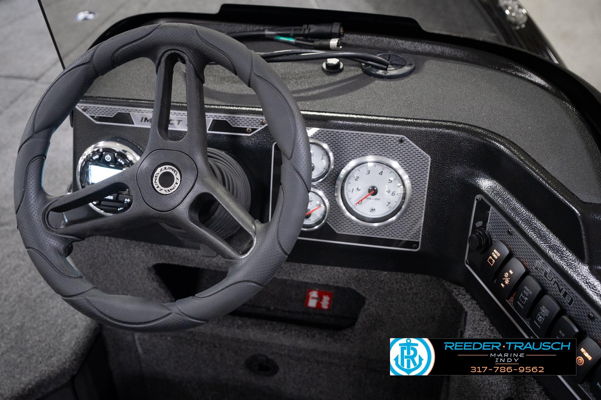 2026 Lund 1775 Impact XS SS boat dashboard with steering wheel and gauges.