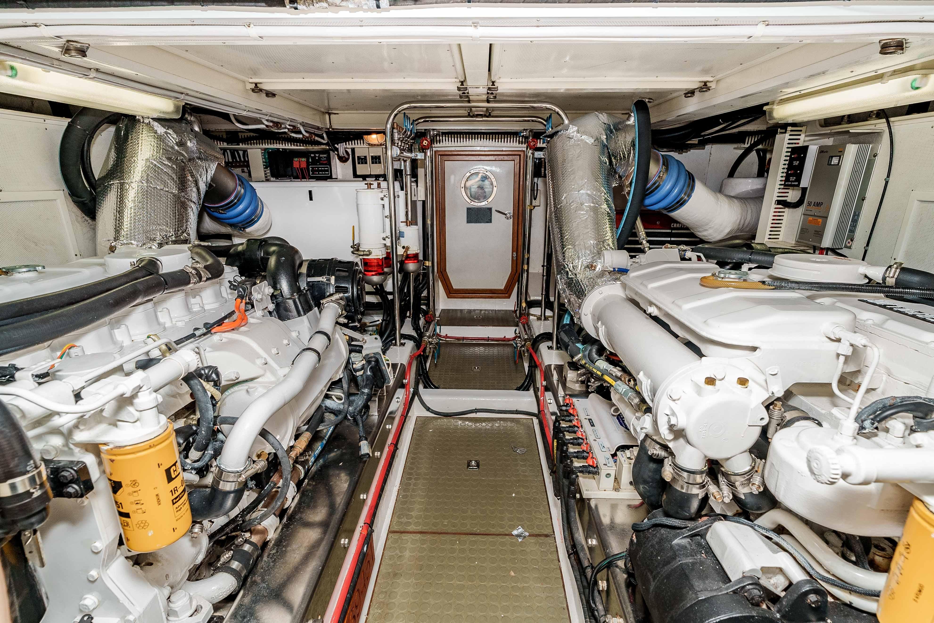 Engine room of a 2005 Offshore Yachts 54 Pilothouse, showcasing dual engines and equipment.