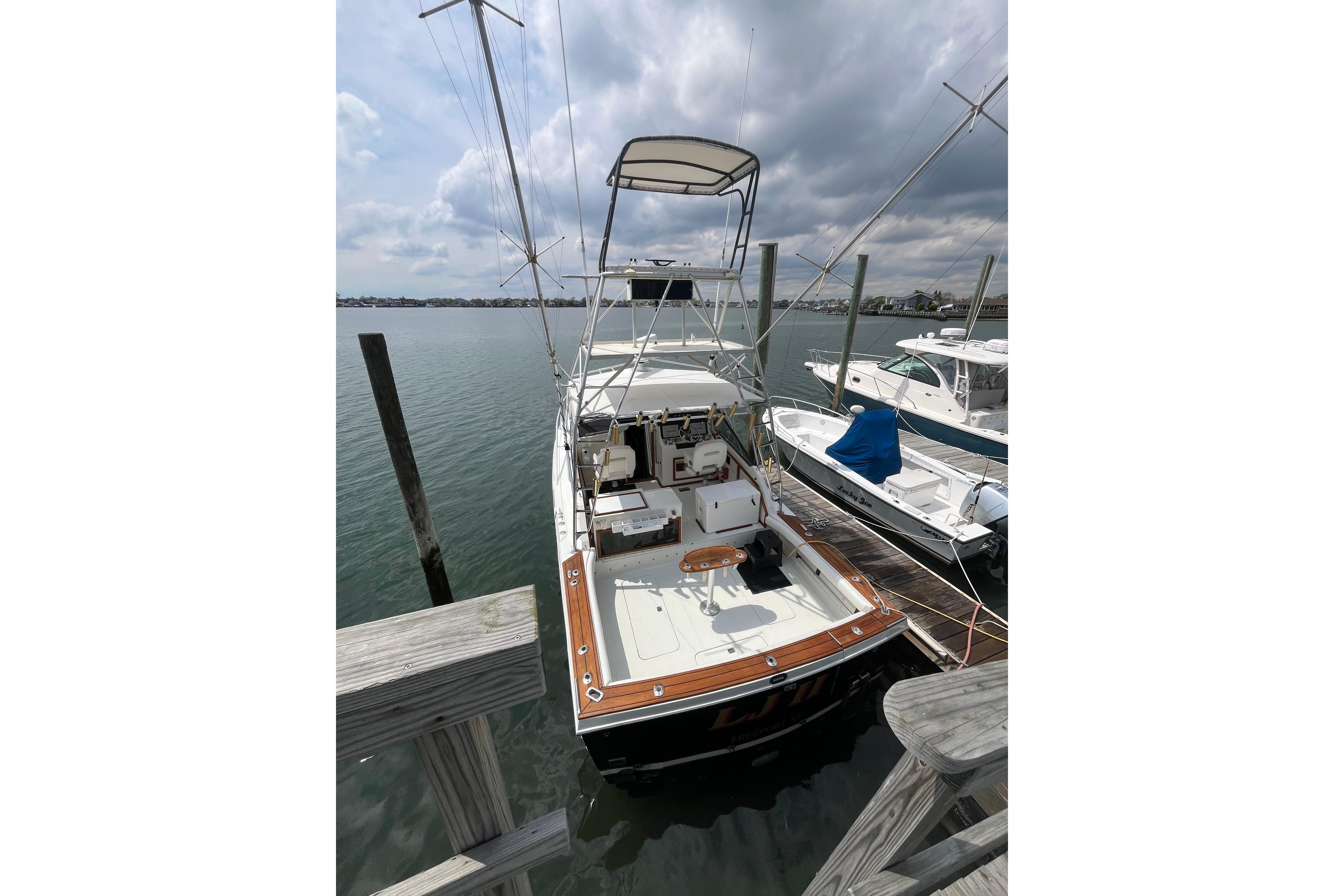 1989 Blackfin 31 Combi boat docked at marina under cloudy sky.
