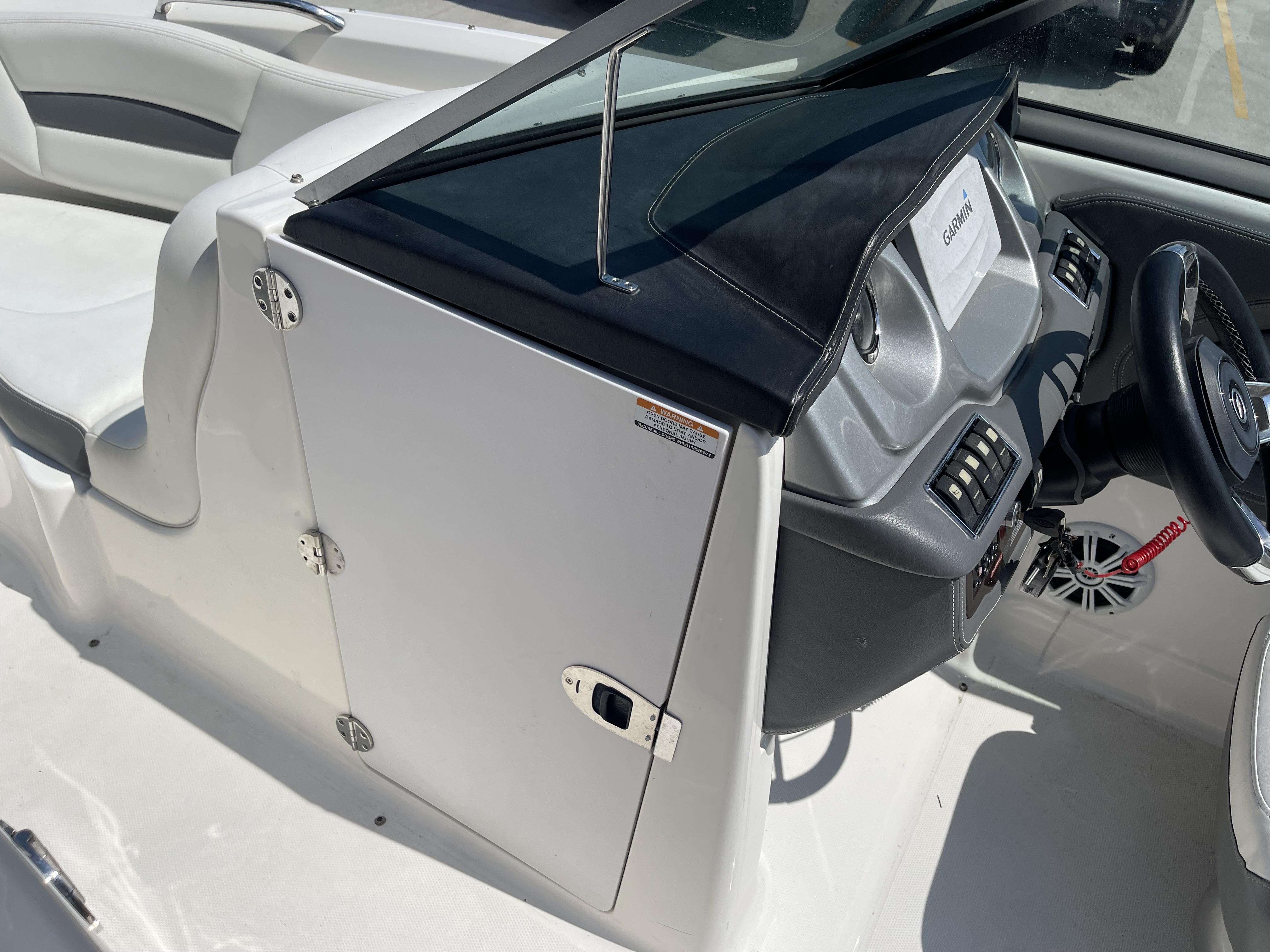 2014 Chaparral Sunesta 224 boat interior with steering wheel and seating area.