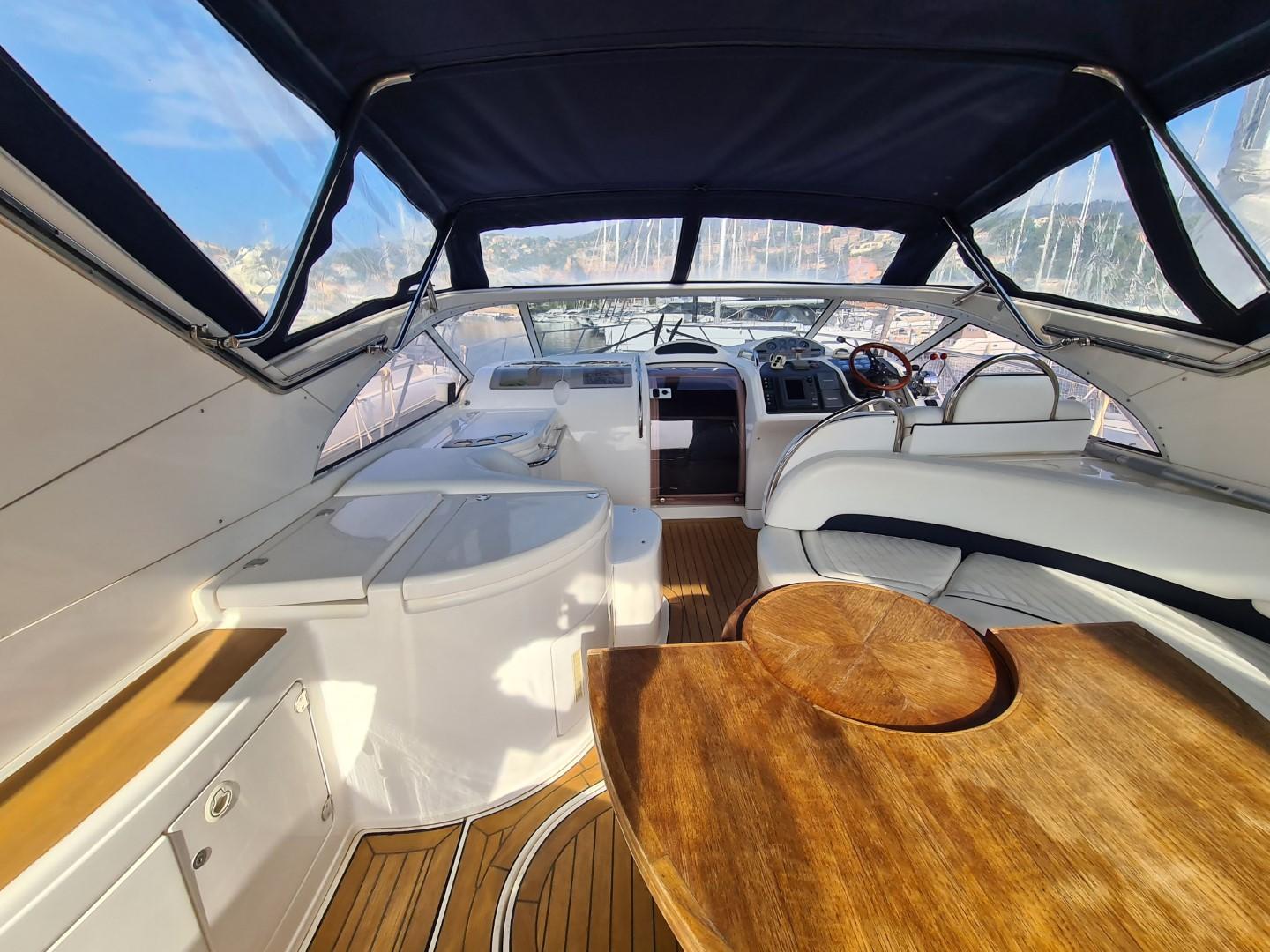 2004 Fairline Targa 43 yacht interior with wooden table and seating area.