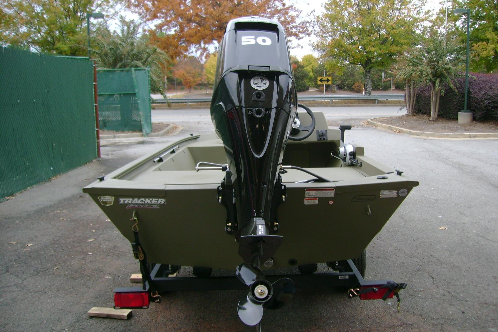 2026 Tracker Grizzly 1648 SC boat with 50 HP motor, parked outdoors.