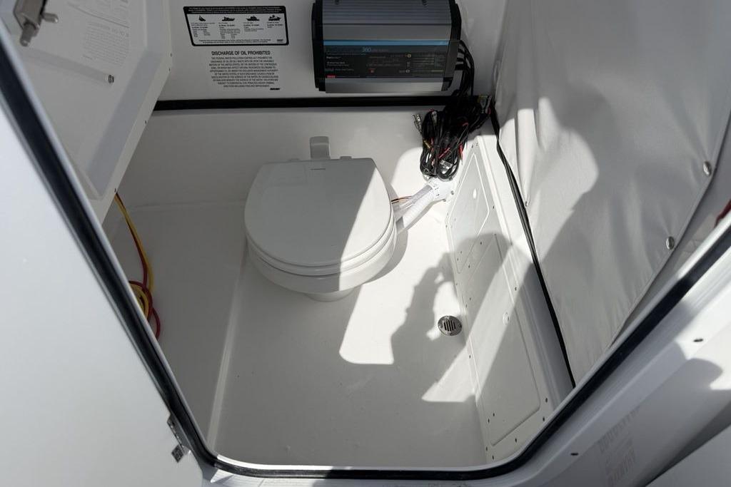 2026 Sportsman Open 252 Center Console boat interior with compact marine toilet.