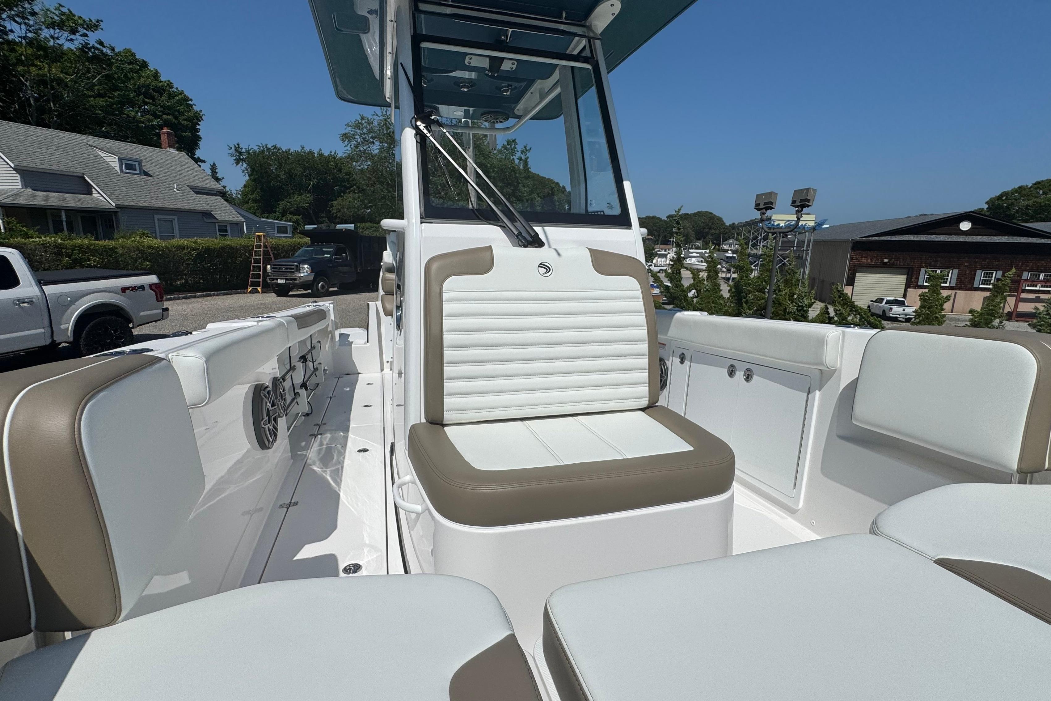 2026 Edgewater 250CC boat interior with white and tan seating, docked outdoors.