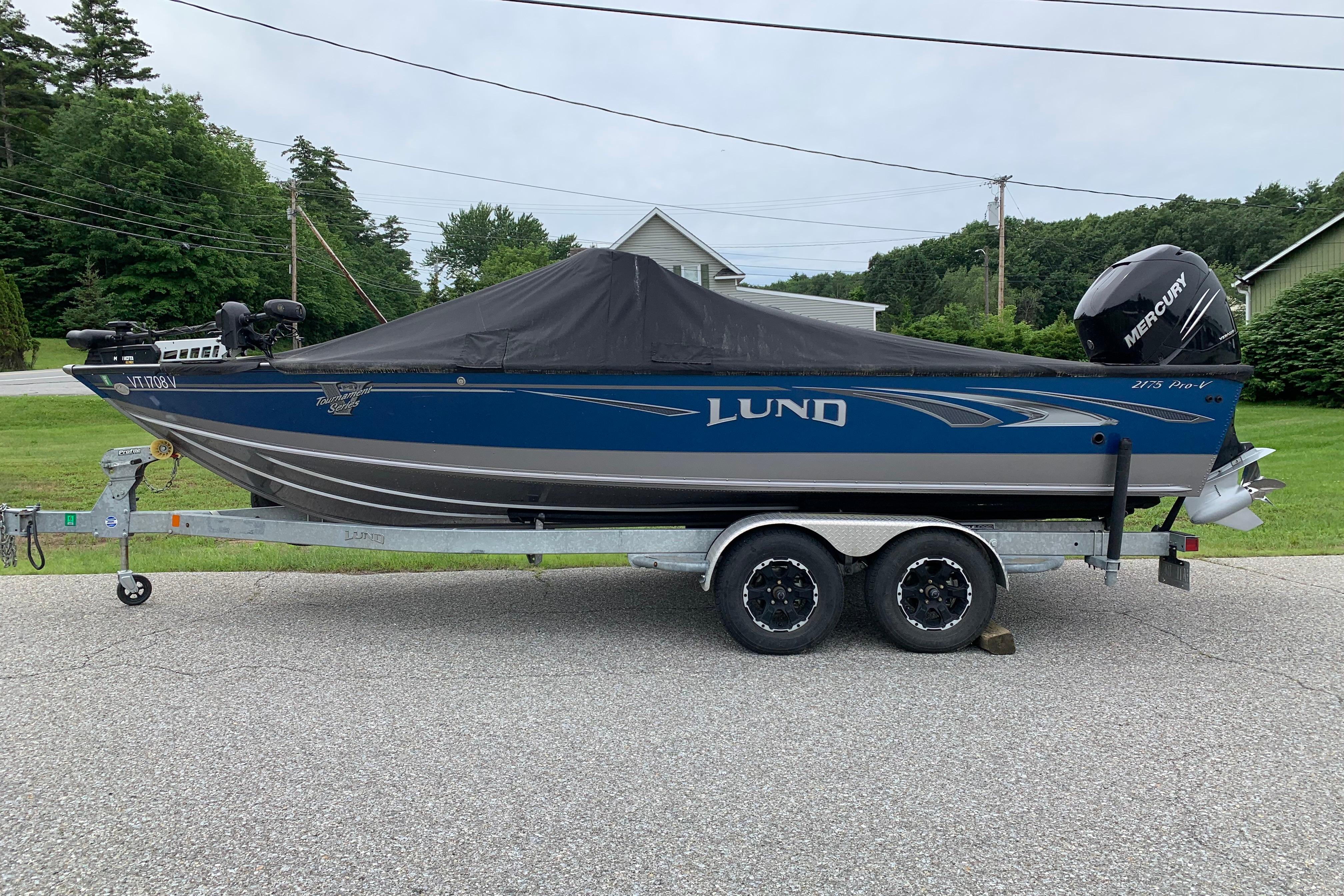 2019 Lund 2175 Pro-V boat on trailer, covered, with Mercury outboard motor.