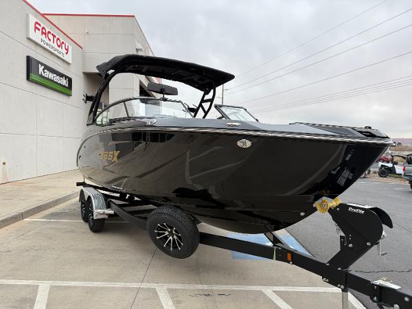 2025 Yamaha Boats 255XD in black on trailer, parked outside dealership.
