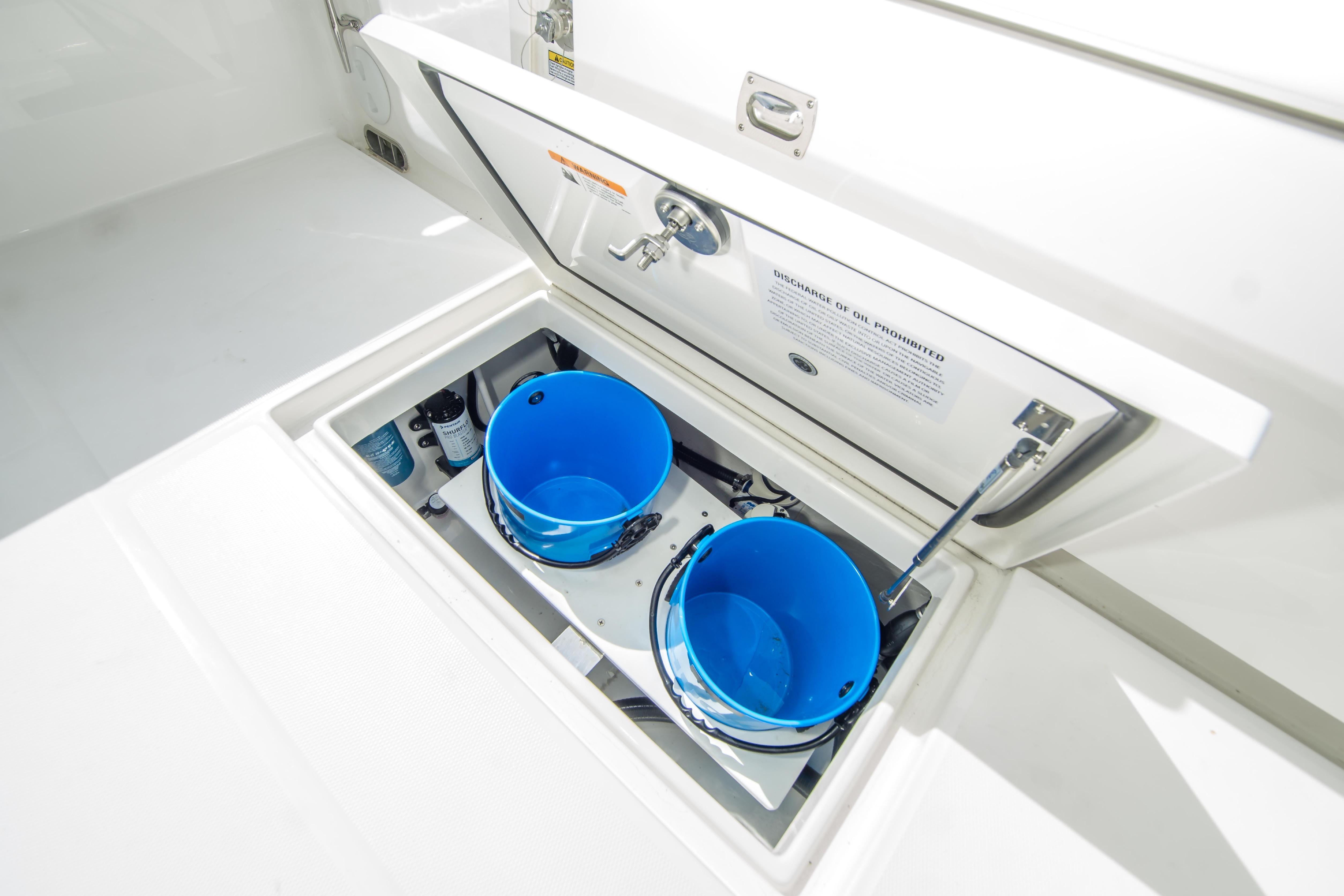 2026 Regulator 23 boat storage compartment with blue buckets and equipment.