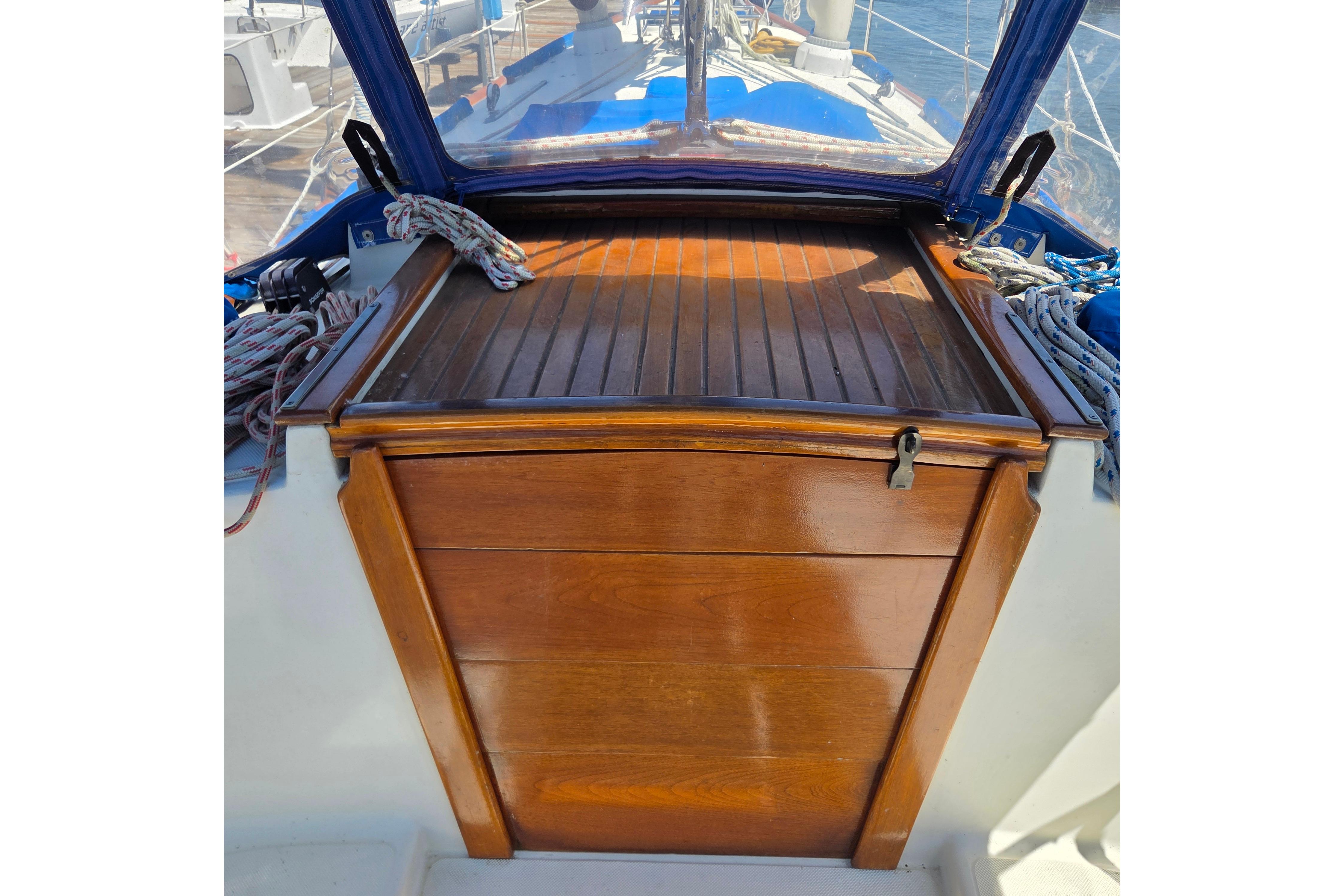 Cockpit view of 1983 Pacific Seacraft 34 sailboat with wooden hatch and ropes.
