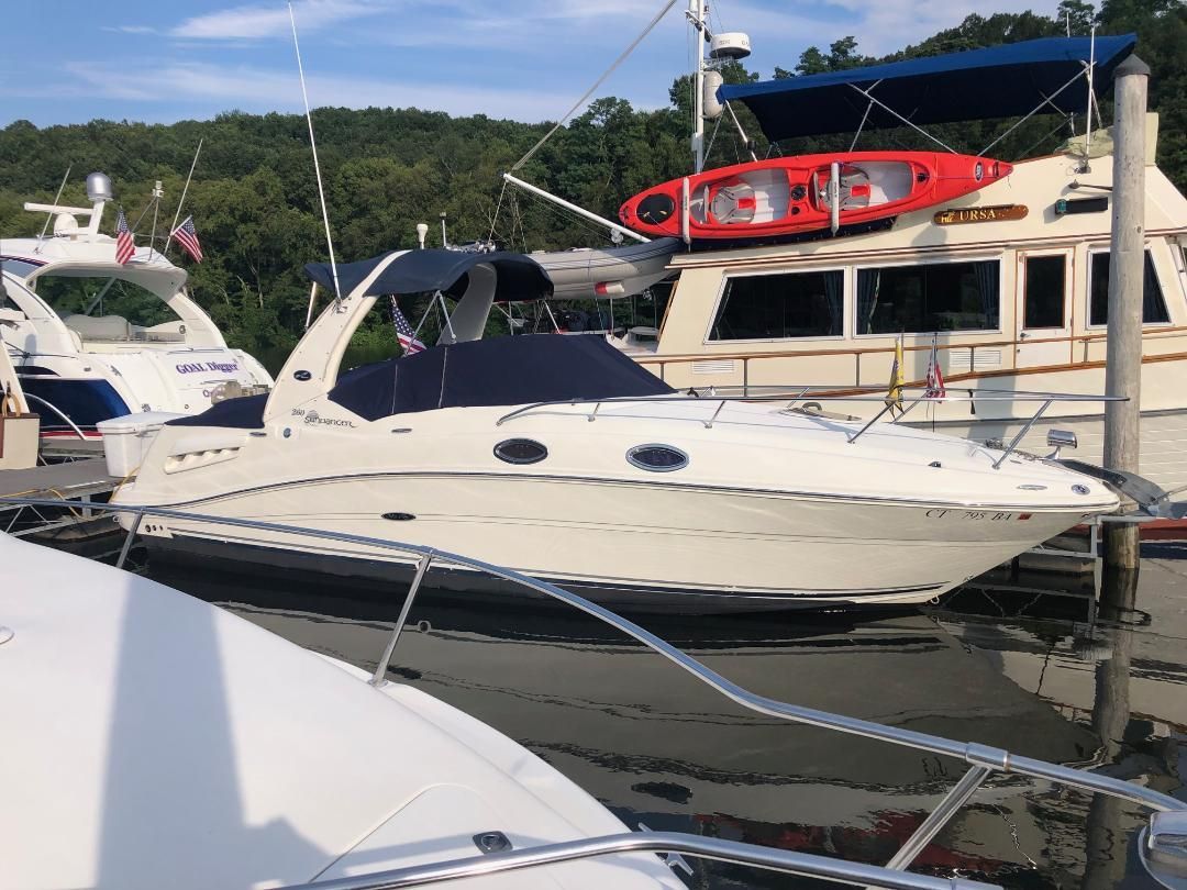 A 2005 Sea Ray Sundancer 260 docked, surrounded by other boats.