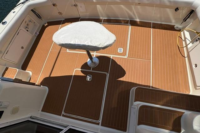 Cockpit of 2000 Silverton 42 Convertible yacht with teak flooring and covered pedestal table.