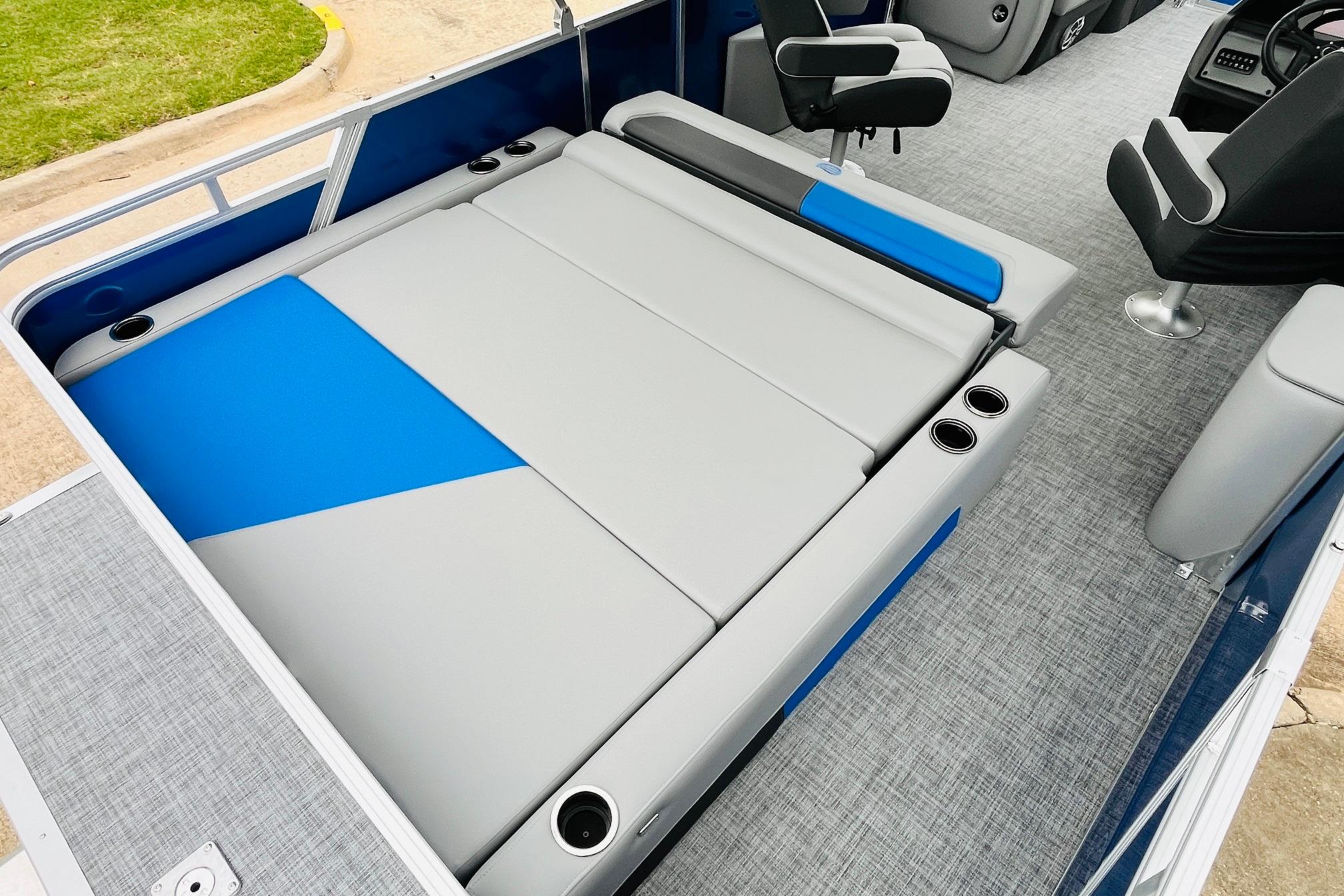 2026 Sun Tracker Party Barge 22 RF DLX interior with gray and blue seating, cup holders.