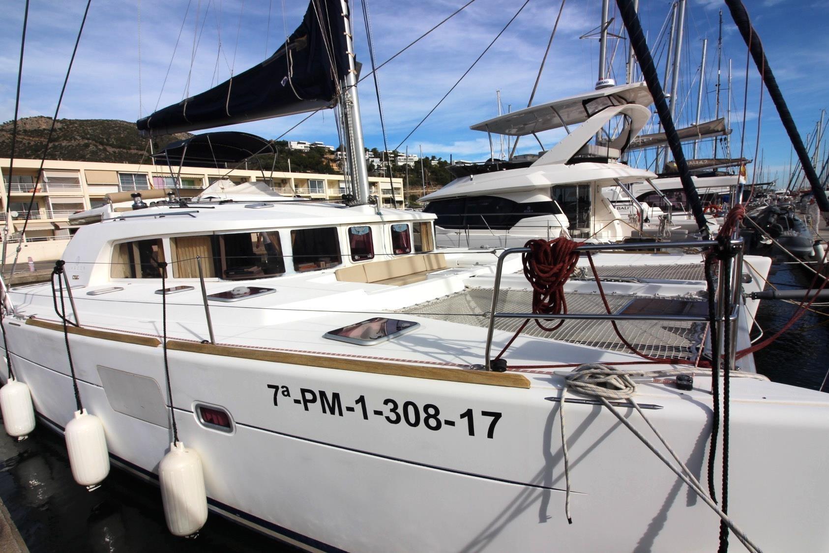 2009 Lagoon 440 catamaran docked at marina, featuring sleek design and spacious deck.