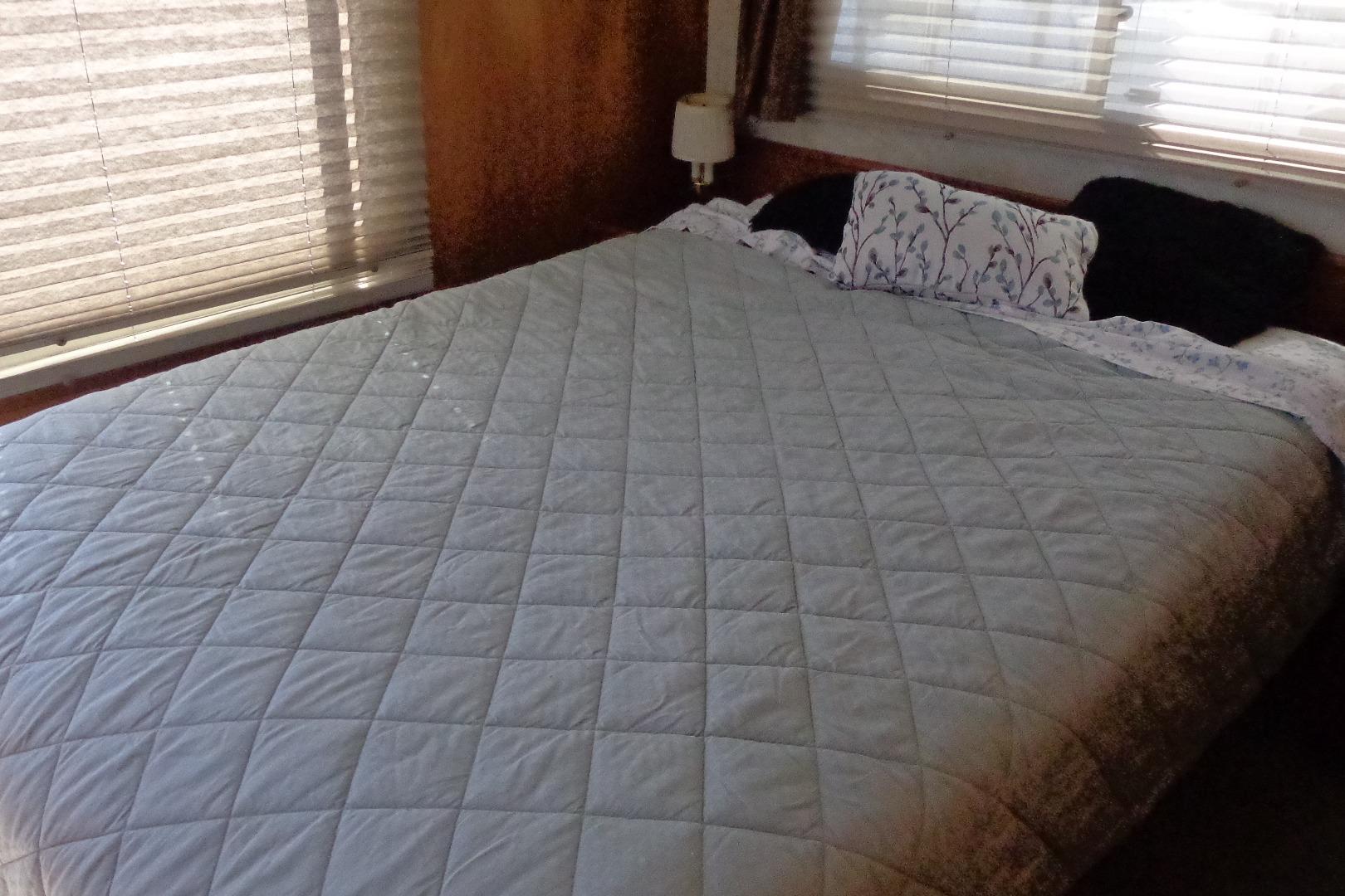 Interior of 1992 Cruise-A-Home Corsair 4200 with a neatly made bed and window blinds.