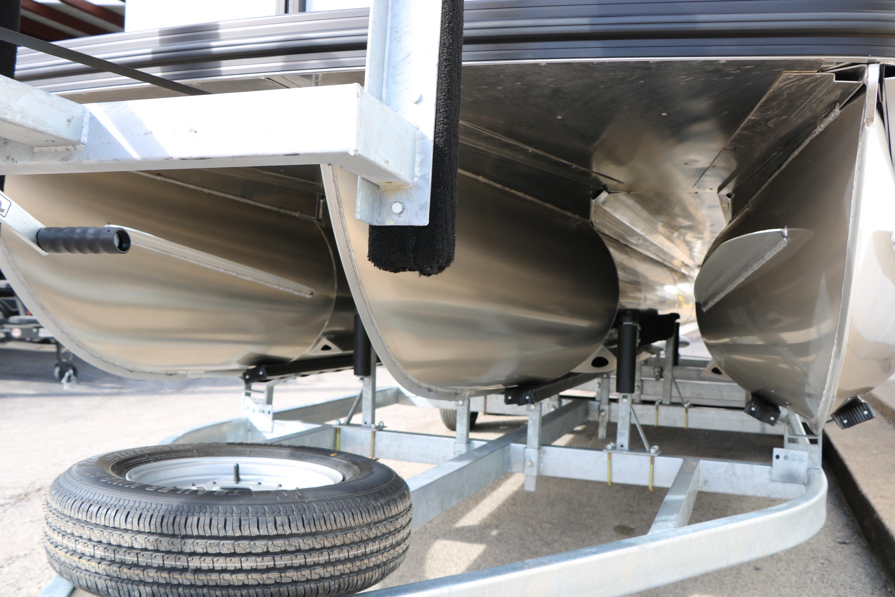 Underneath view of 2026 Evotti 523CS pontoon boat on trailer.