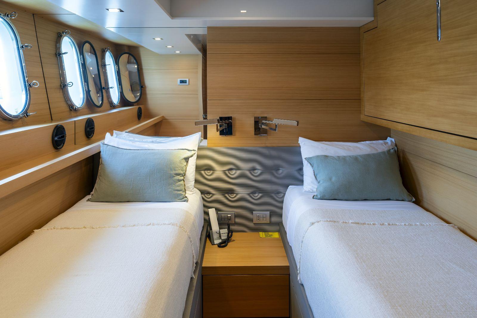 Luxurious twin cabin interior on 2011 Maiora 27 yacht with modern wood finish.