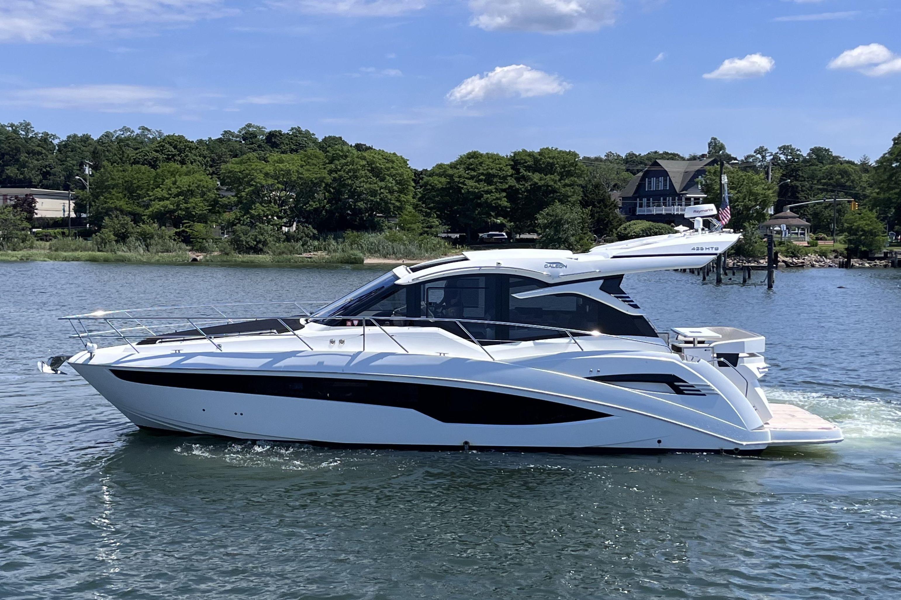2024 Galeon 425 HTS yacht cruising on a serene lake under a clear blue sky.