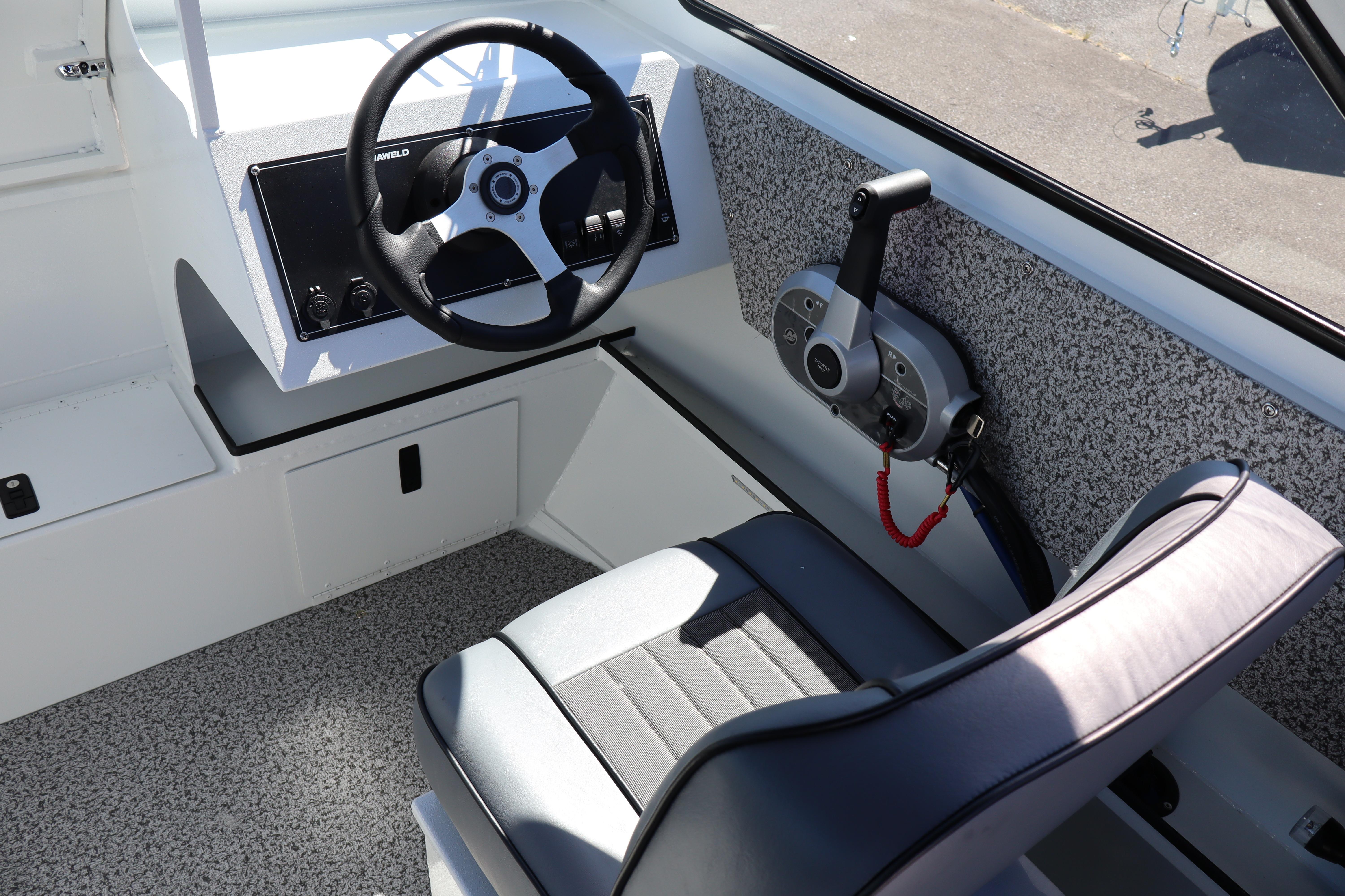 Interior of 2026 Alumaweld Stryker 202 boat, featuring steering wheel and control panel.