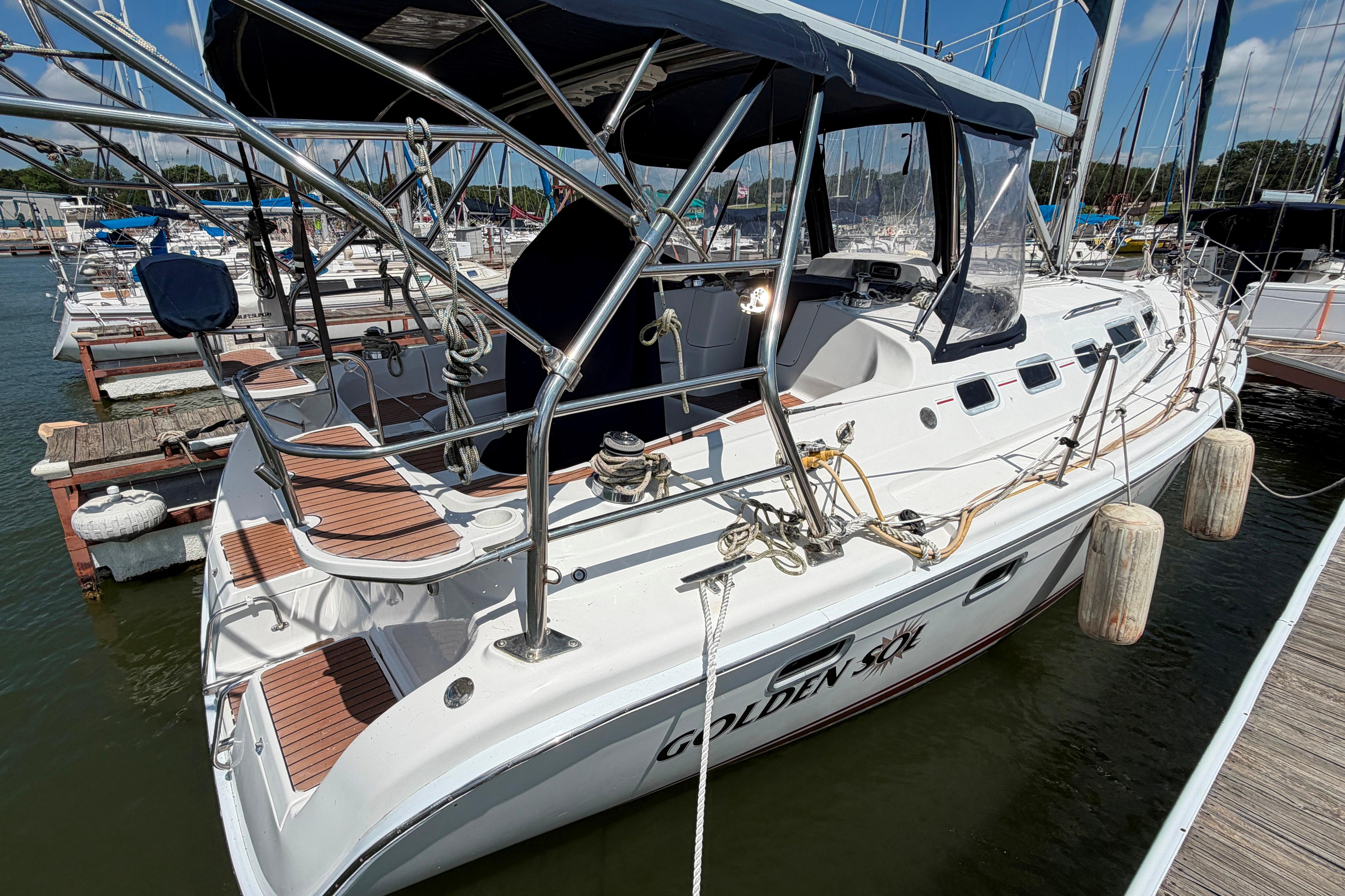 2005 Hunter 38 sailboat docked at marina, featuring sleek design and spacious deck.