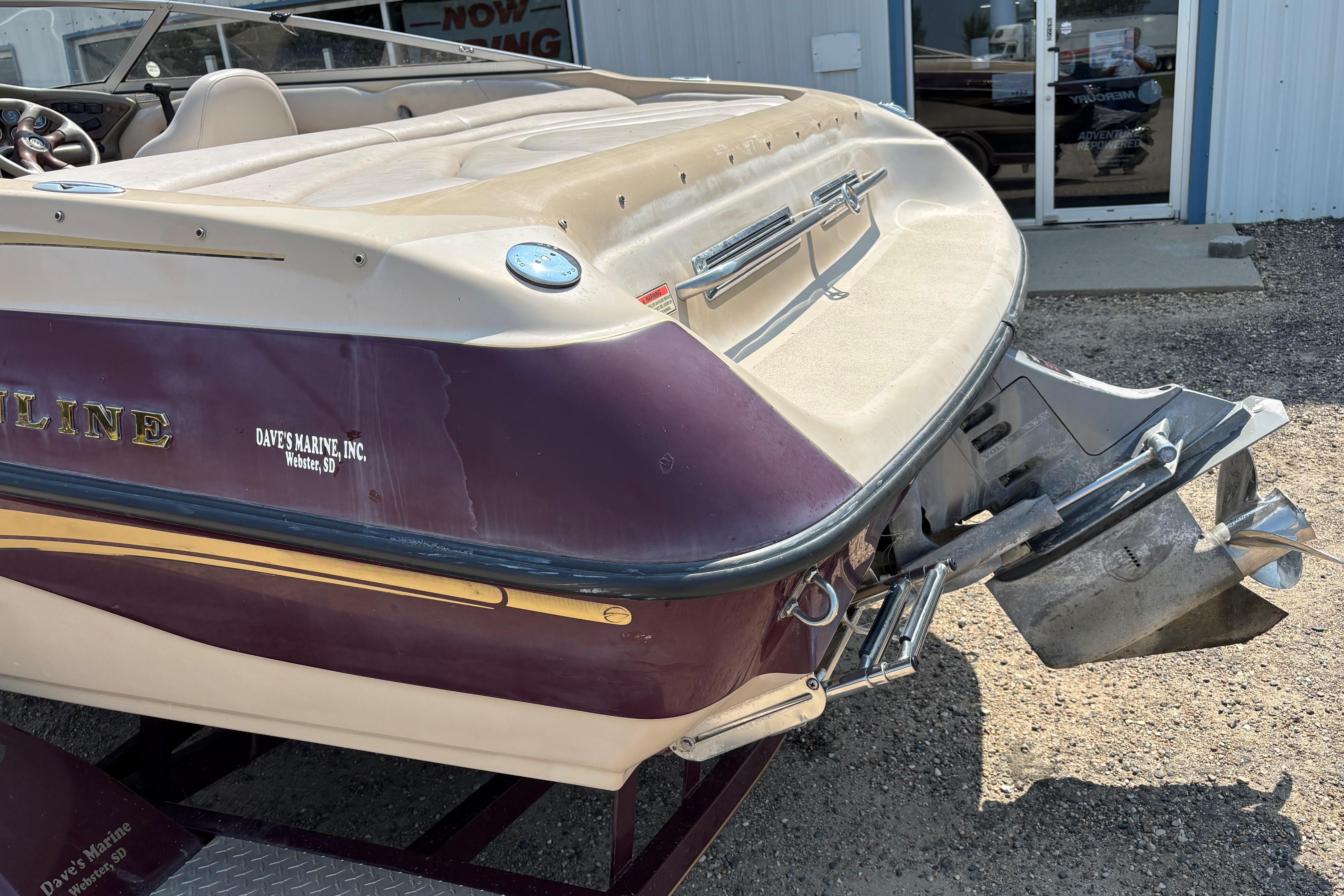 2001 Crownline 18' boat with outboard motor, parked outside a building.