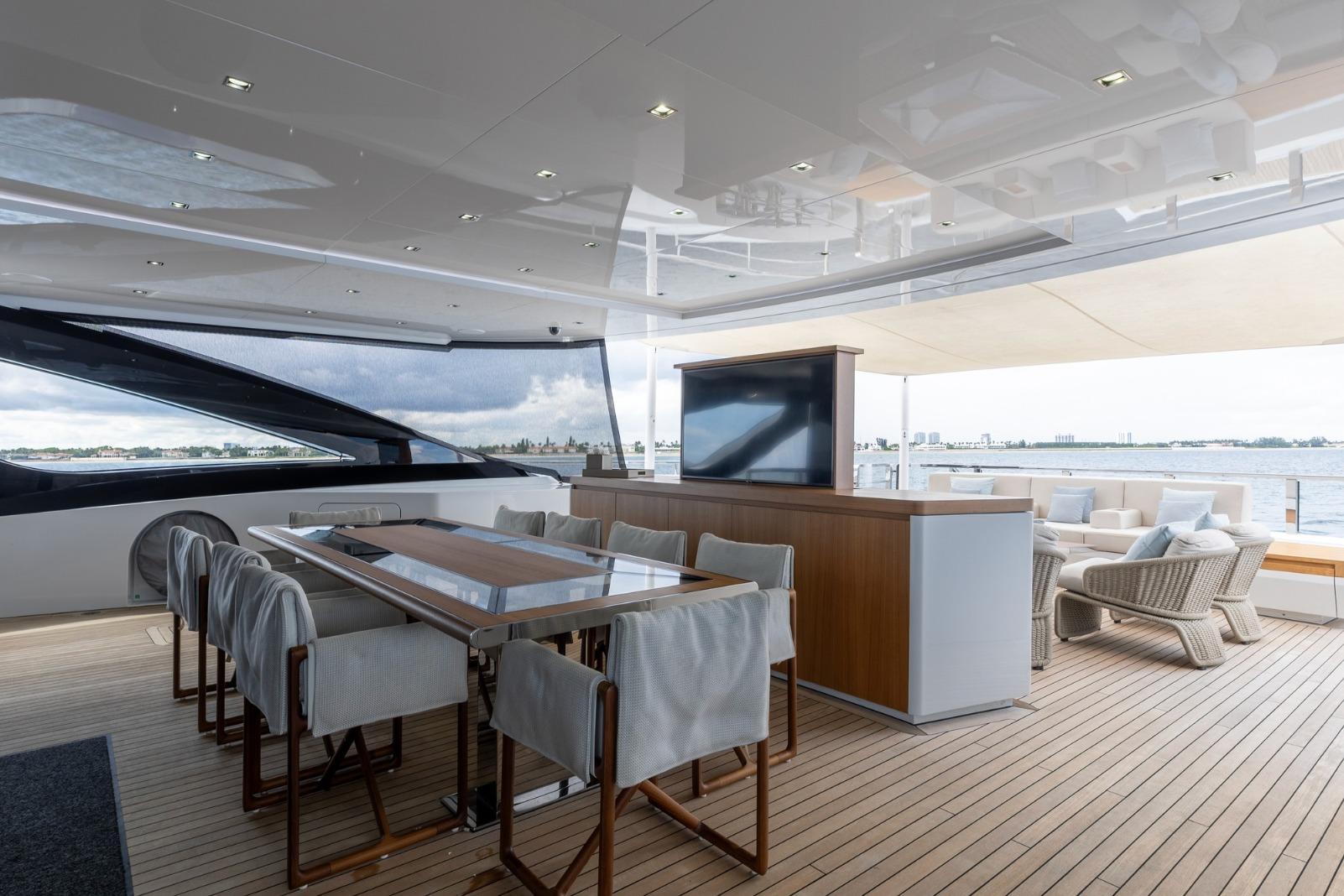 Luxurious 2020 Overmarine Gransport 54 yacht deck with elegant dining area and ocean view.