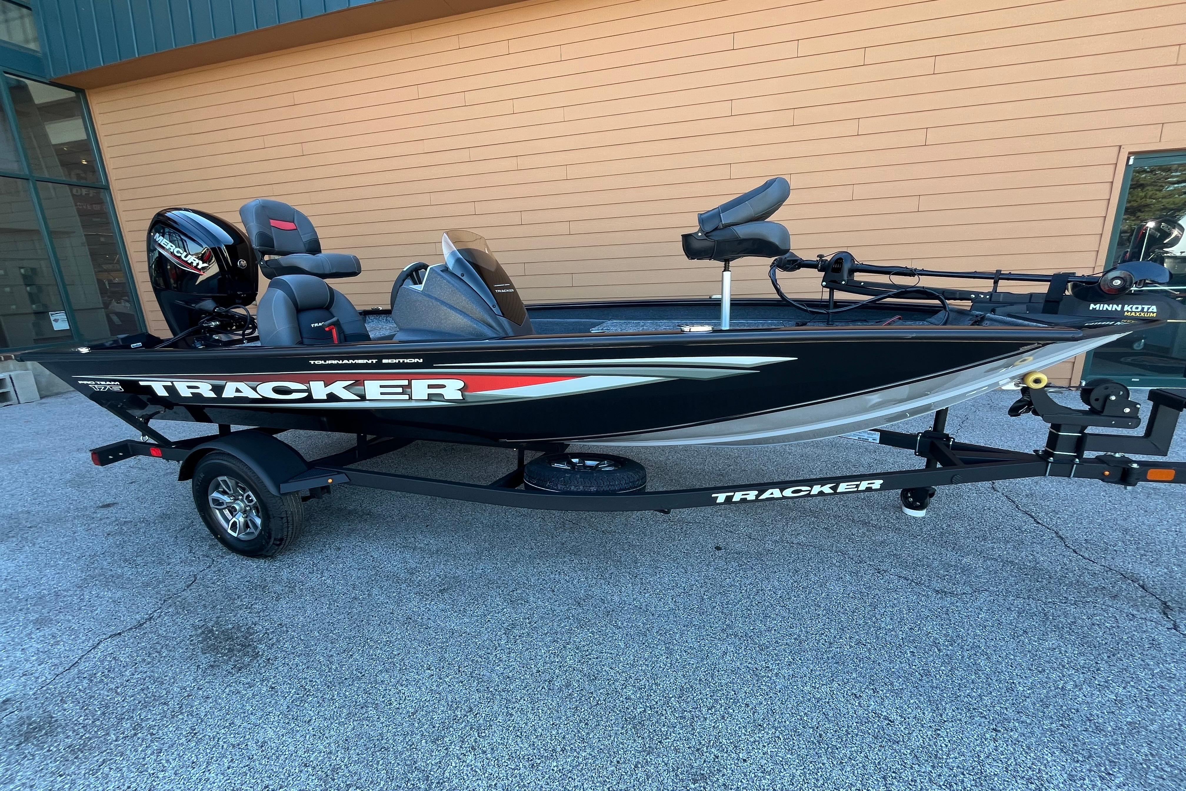 2026 Tracker Pro Team 175 boat on trailer, black with red accents, parked outdoors.