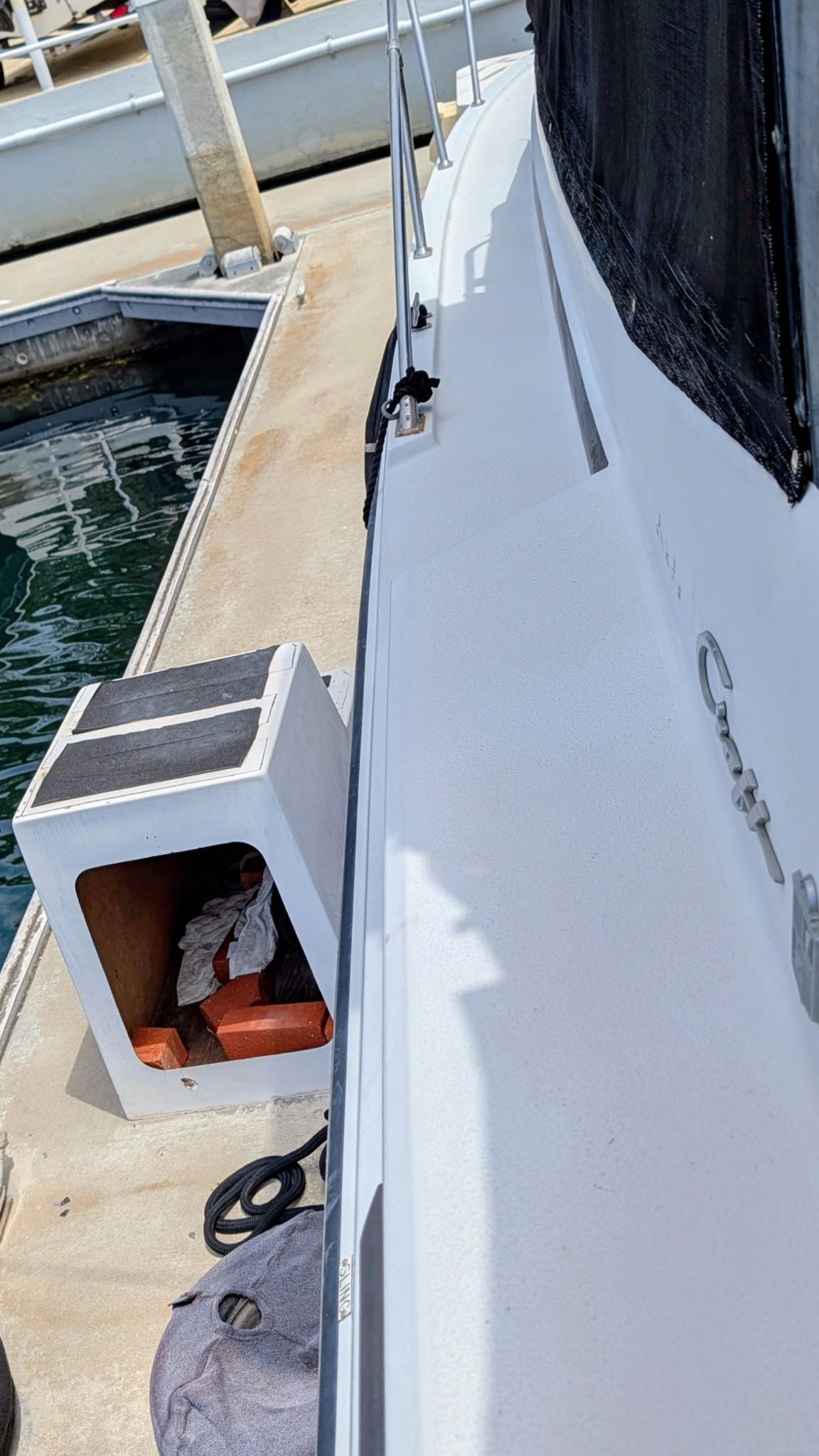 A 1987 Chris-Craft 320 Amerosport Express at a dock. Visible are the deck and a storage compartment.