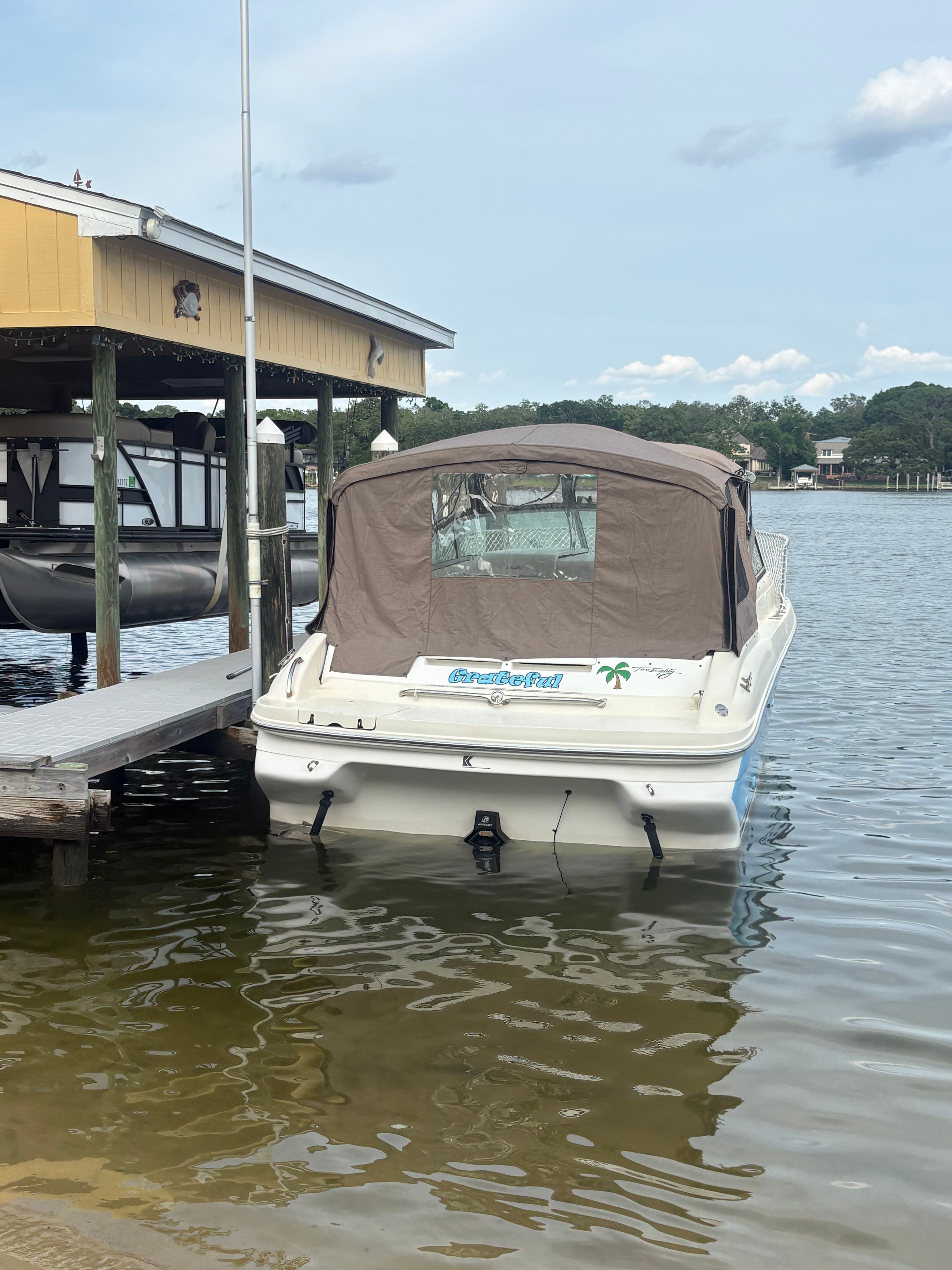 A 1996 Sea Ray 280 Cuddy Cabin boat docked in calm water.