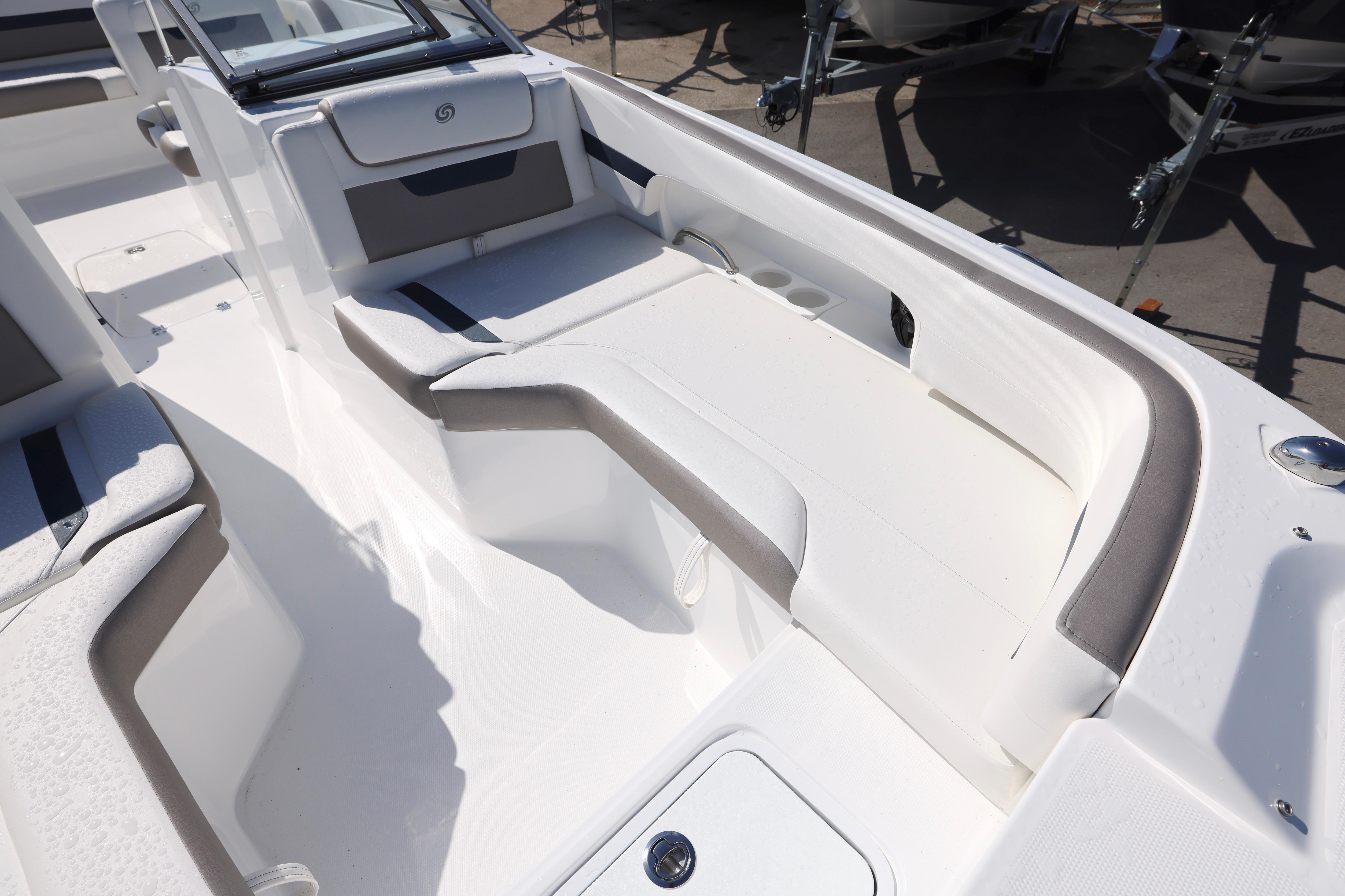 2026 Hurricane SunDeck 235 OB boat interior with white seating and cup holders.