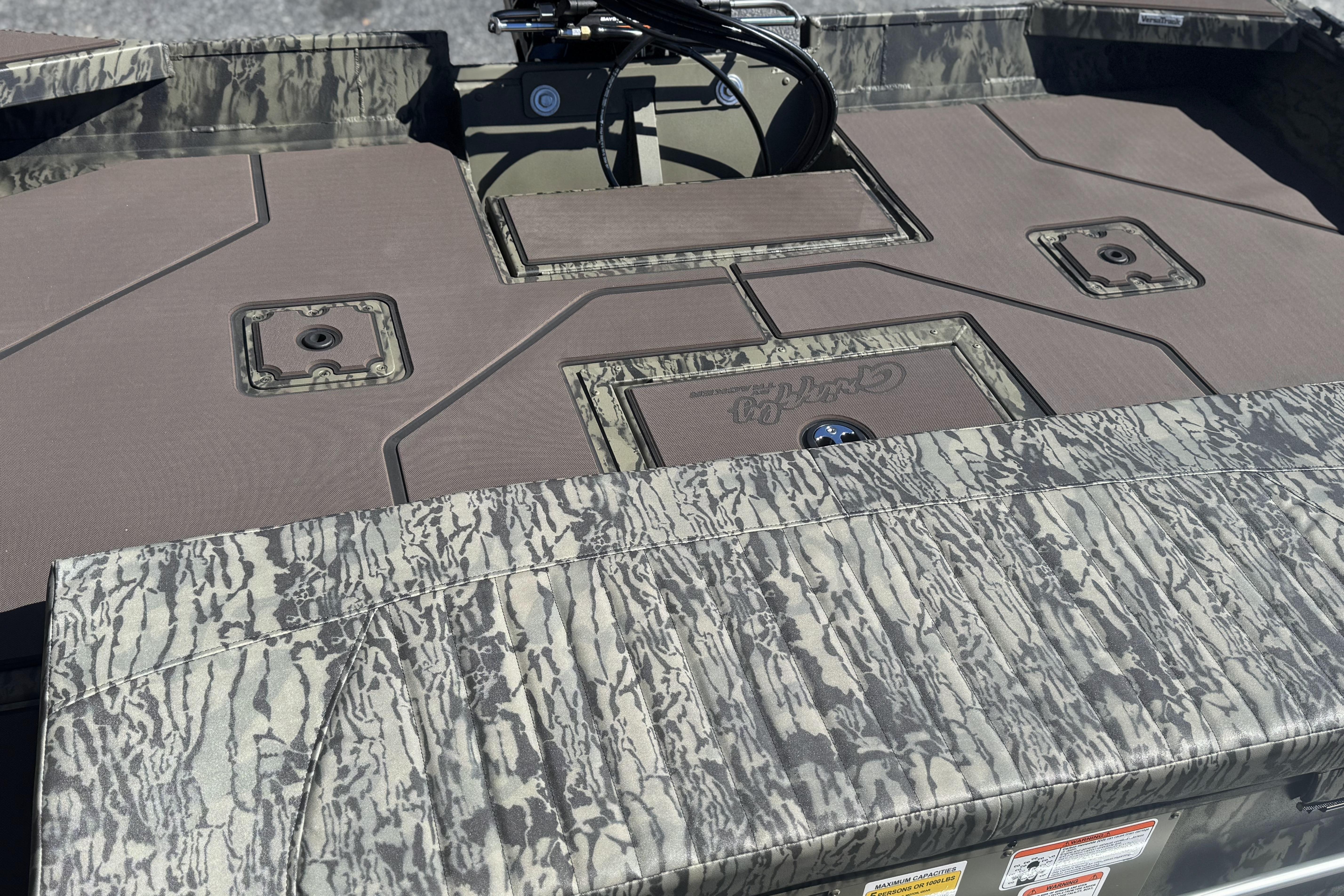 2026 Tracker Grizzly 2072 CC boat deck with camouflage pattern and storage compartments.