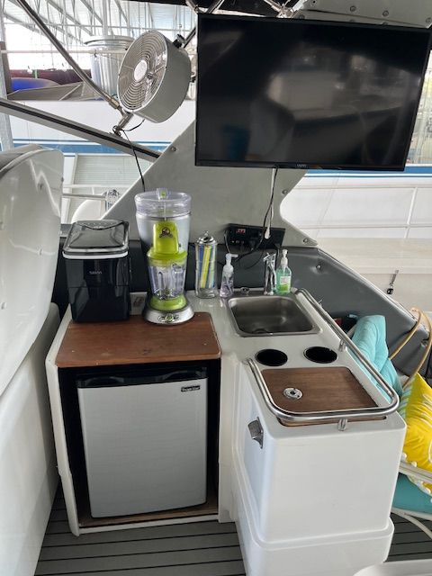 Galley area on a boat with sink, fridge, and blender.