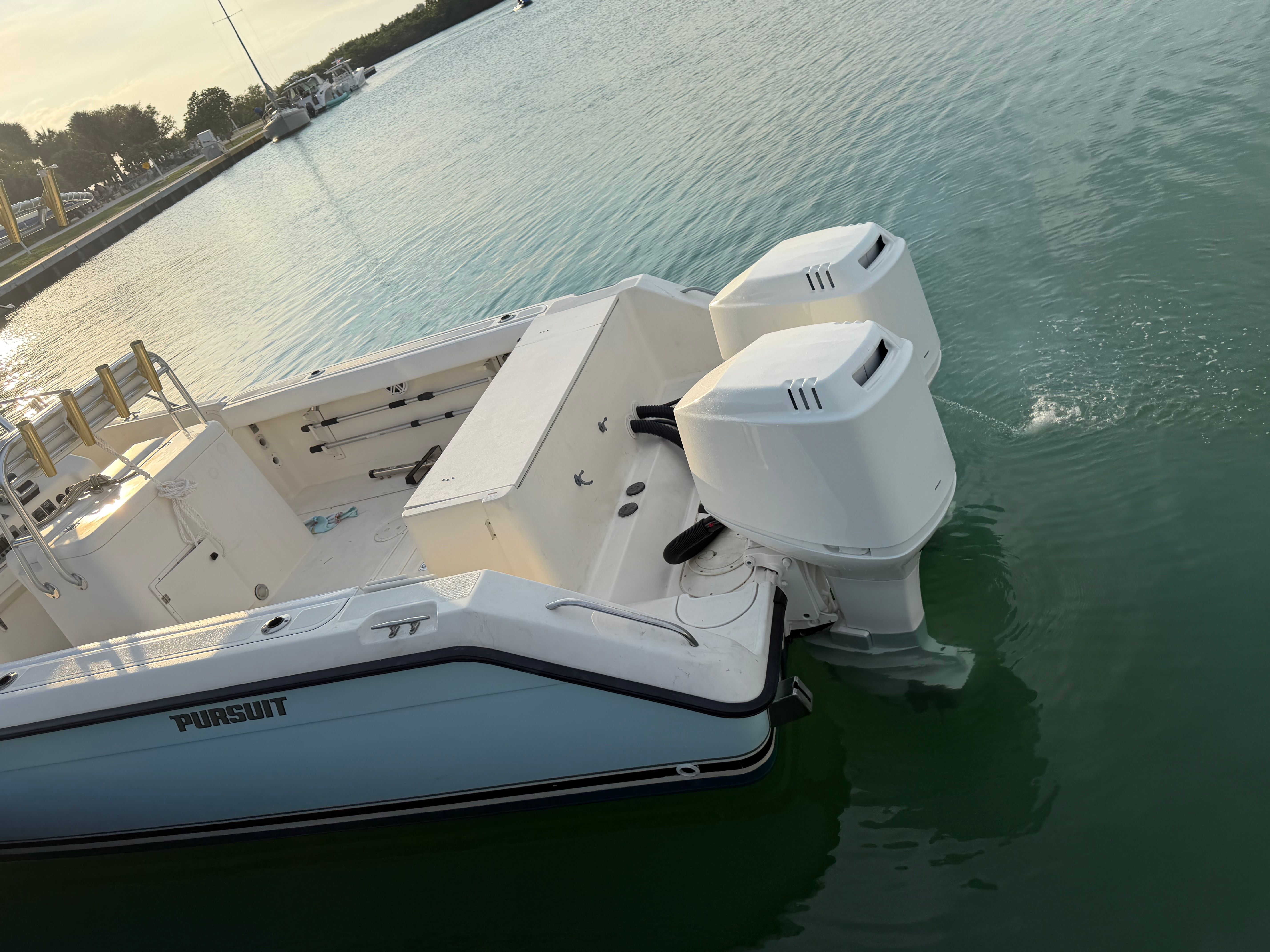 2004 Pursuit 2870 boat on water with twin outboard engines.