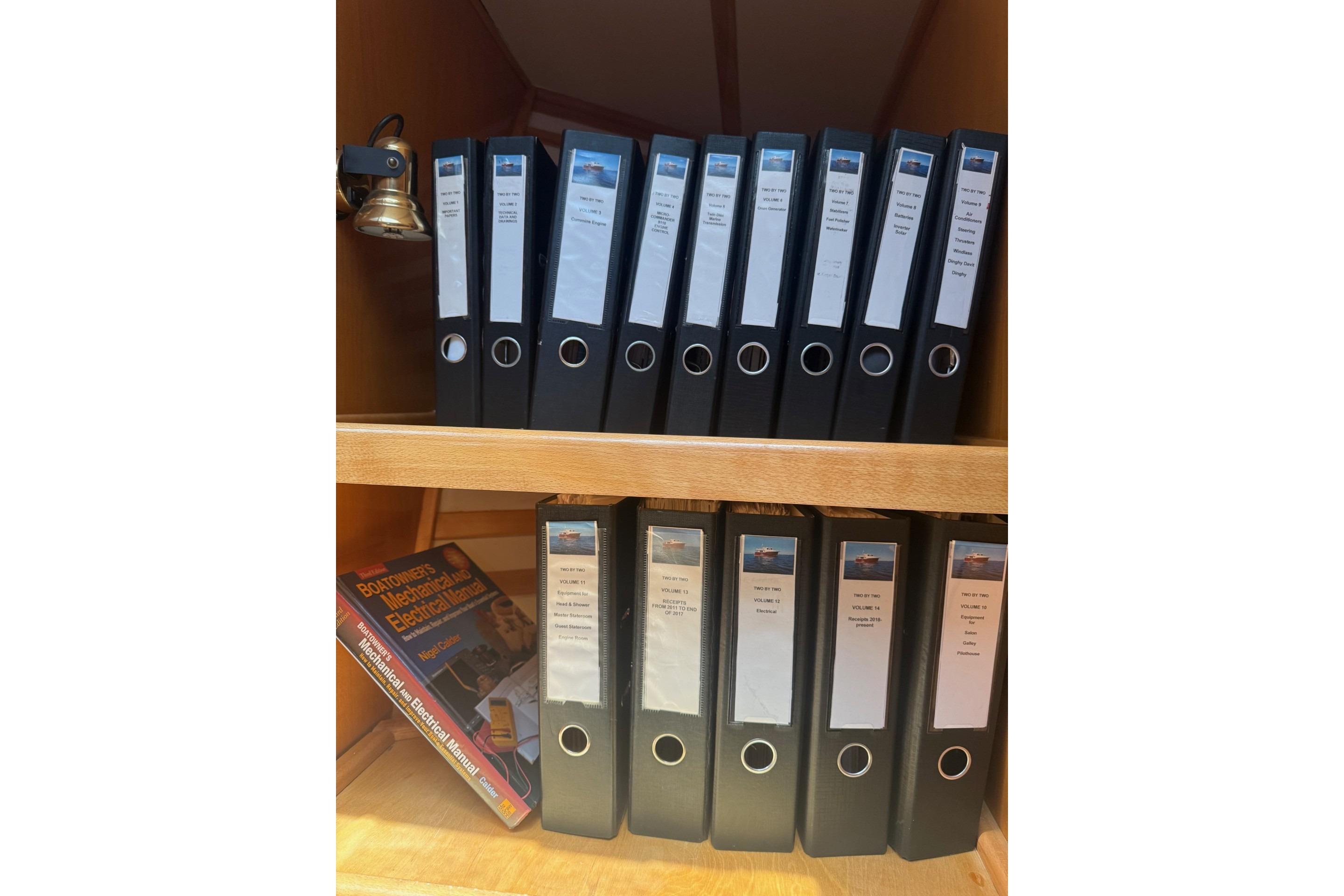Shelves with organized binders and a book, related to Magna Marine Nova Scotia 47, 2003.