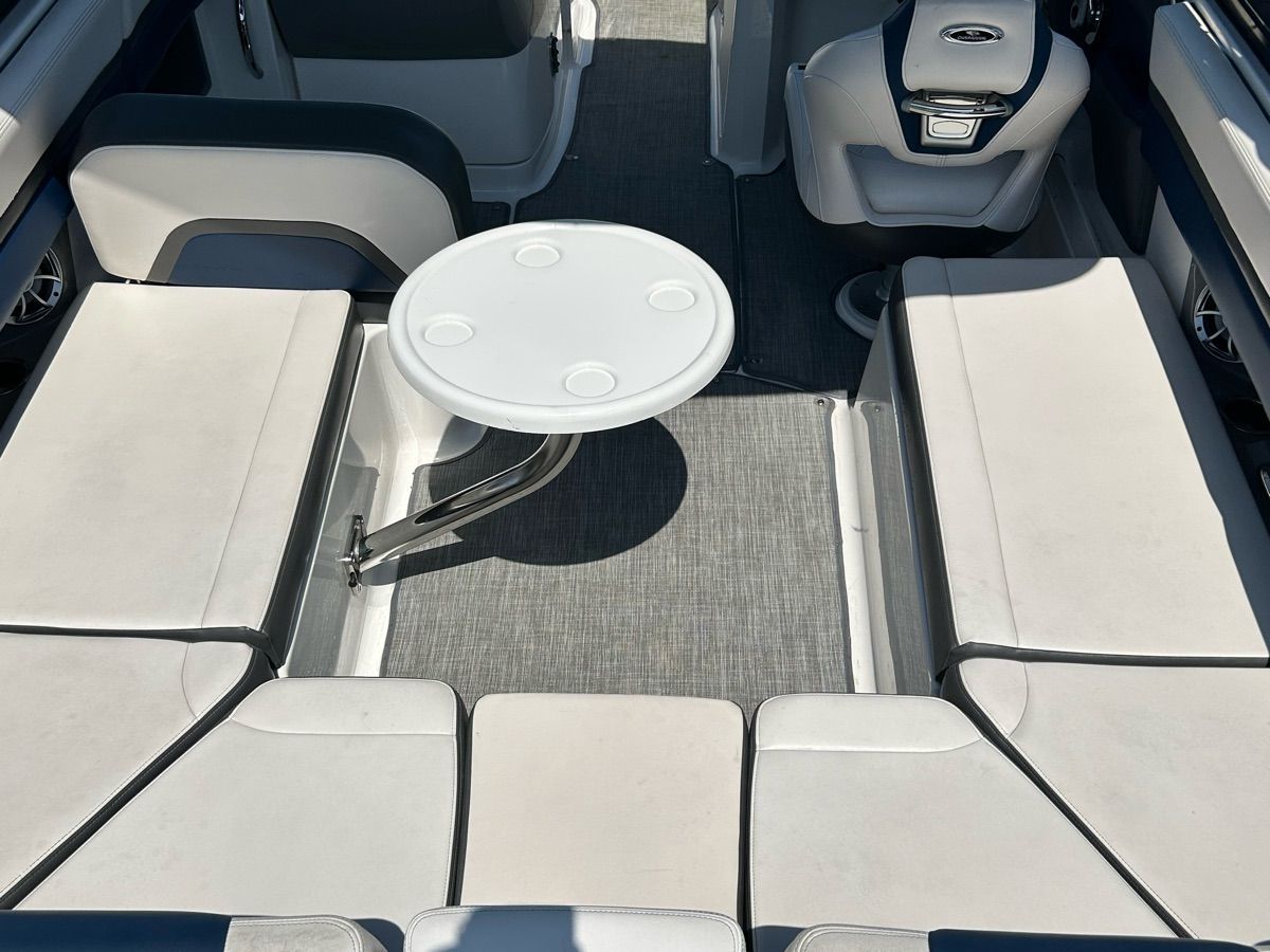 Interior of a 2016 Chaparral Vortex 243 VRX with white seating and a round table.