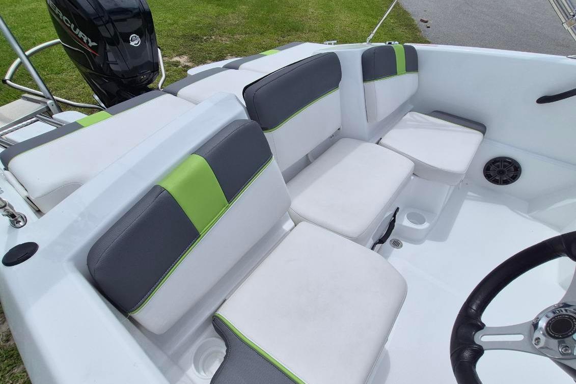 Interior of 2021 Tahoe T16 boat with gray and green seating, featuring a Mercury engine.