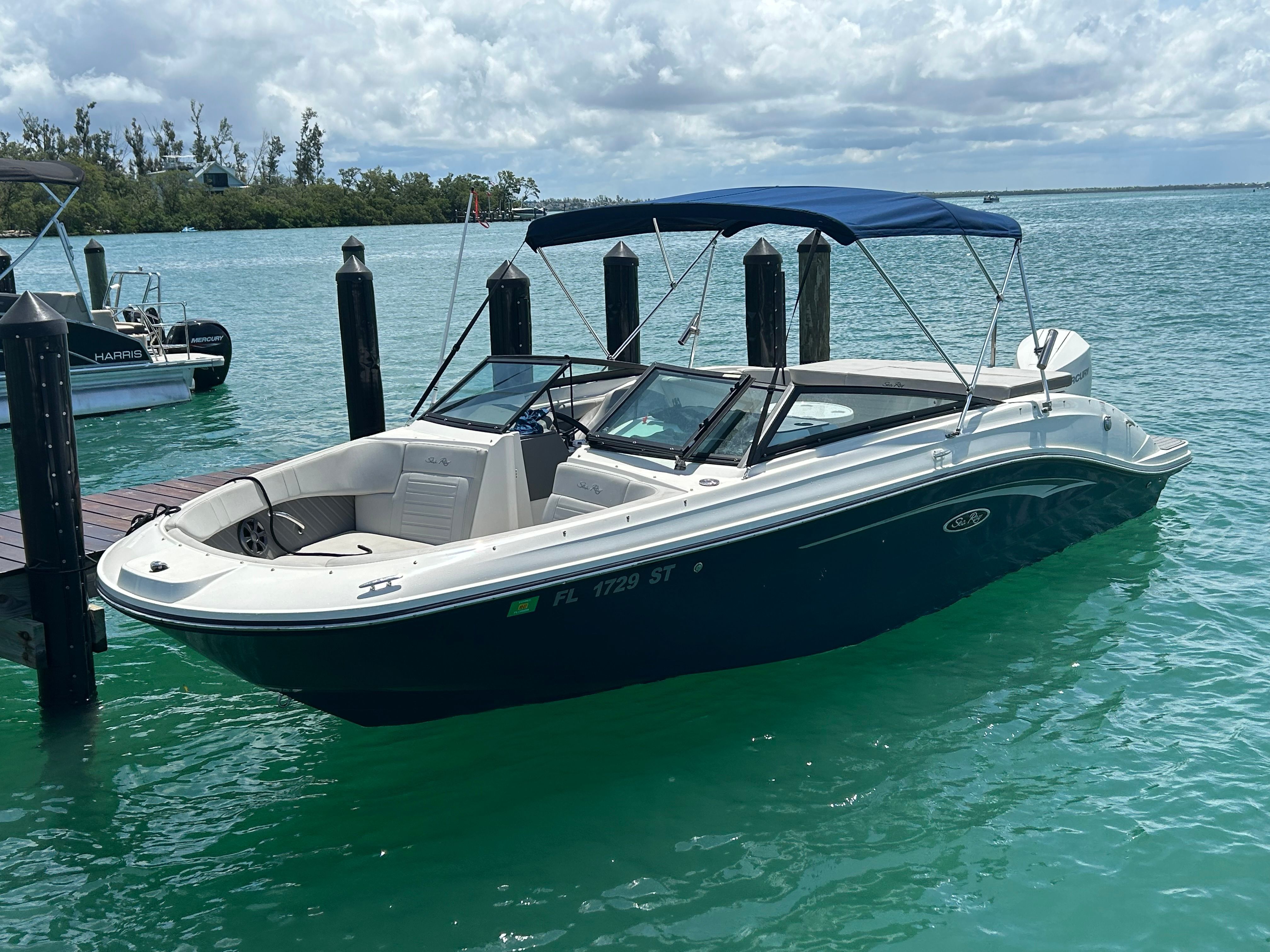 A 2020 Sea Ray SPX 230 Outboard docked in clear water.
