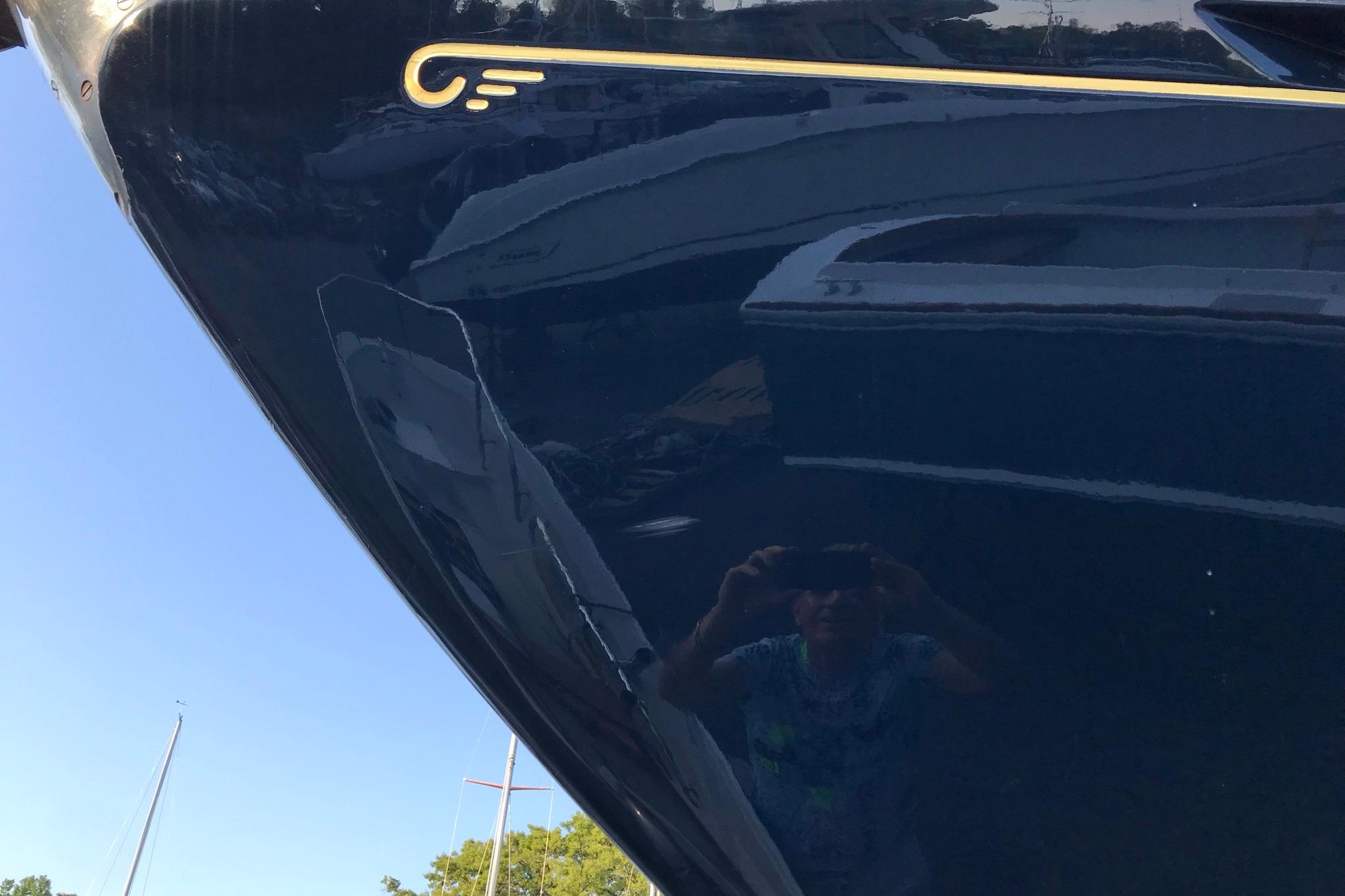 Close-up of a 1970 Hinckley Bermuda 40 yacht hull with reflection.