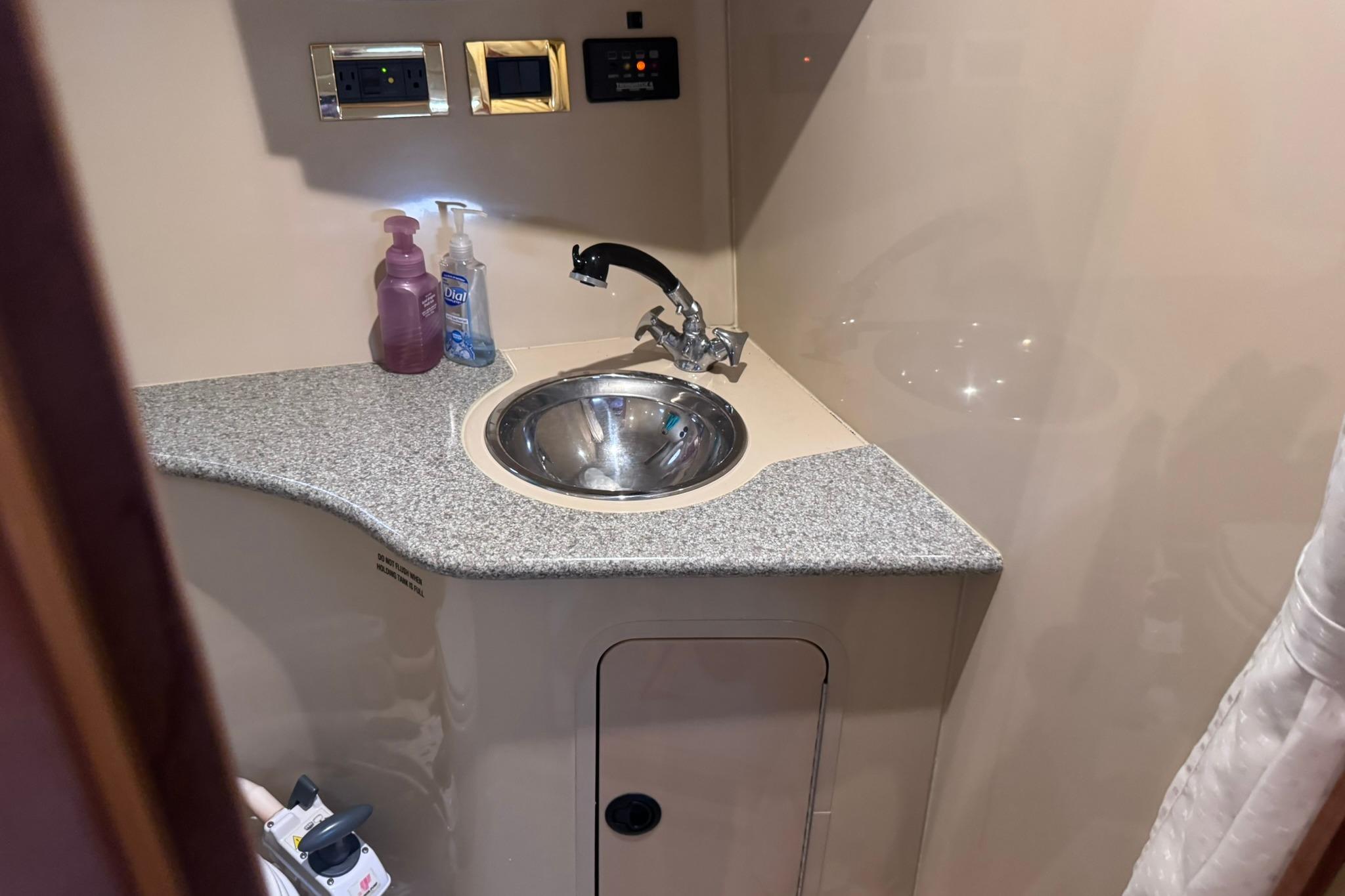 2002 Cruisers Yachts 3275 Express bathroom sink with granite countertop and faucet.