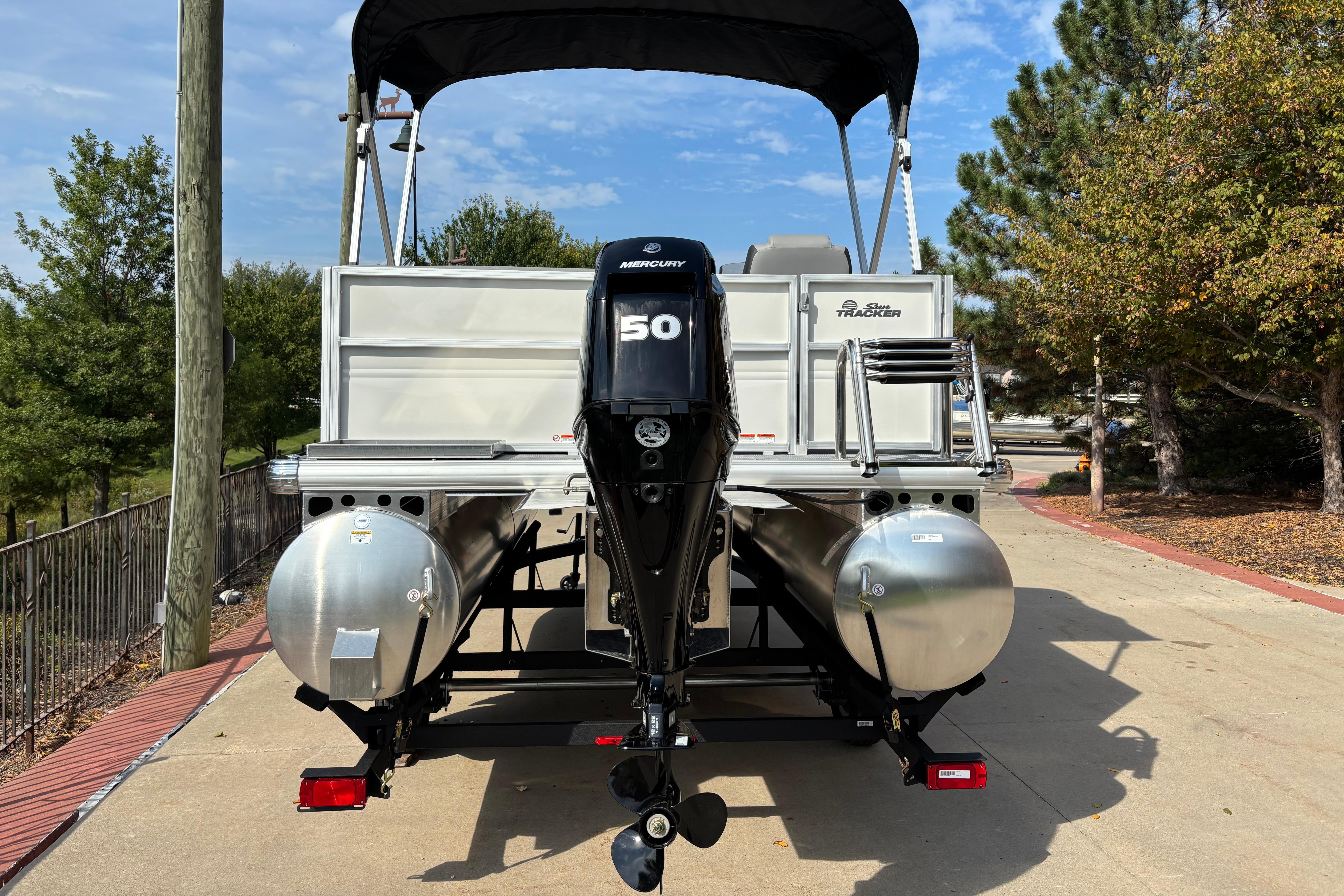 2026 Sun Tracker Party Barge 16 DLX pontoon boat with Mercury 50 engine, parked outdoors.
