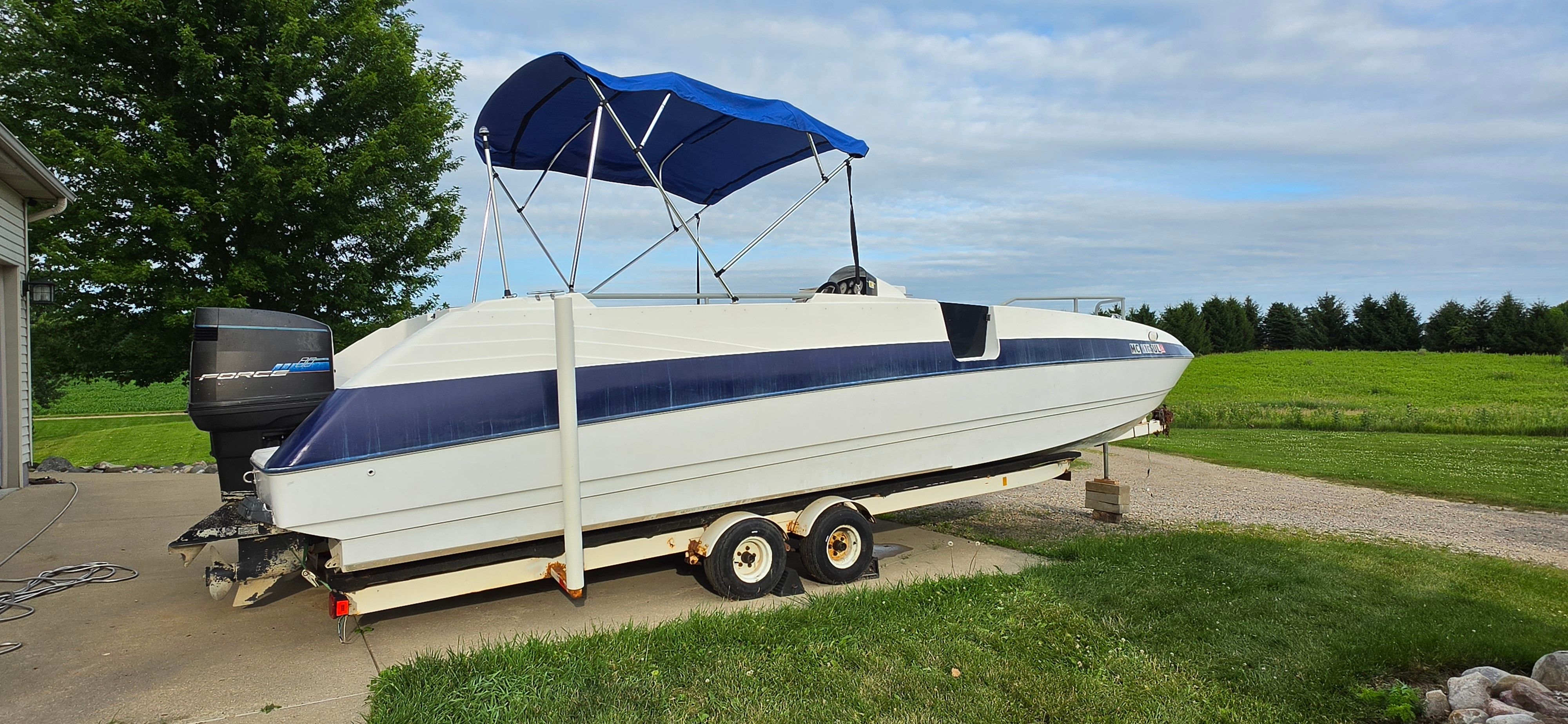 A 1992 Bayliner Rendezvous on a trailer with a blue sunshade.