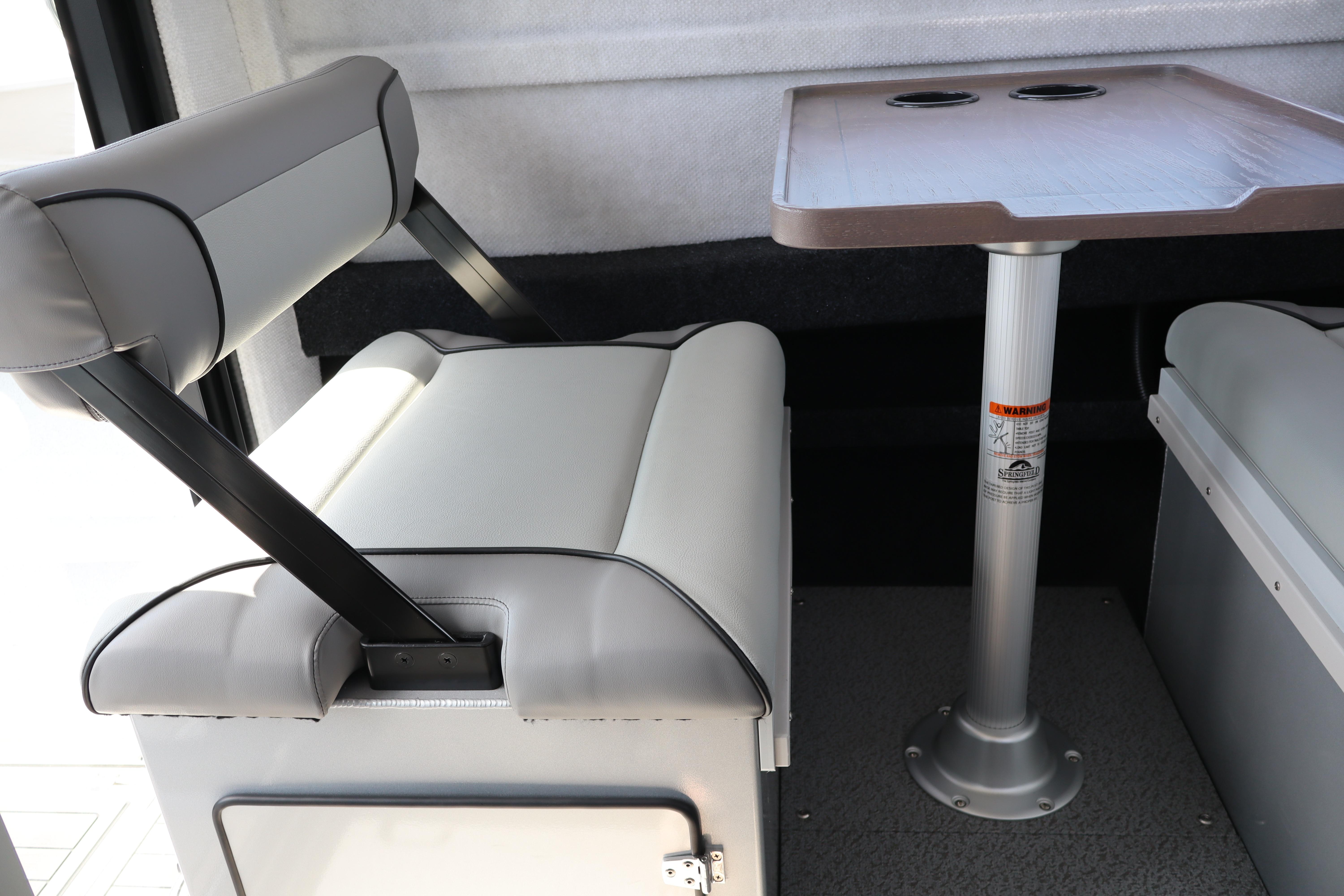 Interior seating and table of 2026 KingFisher 25 XAC boat, featuring modern design.