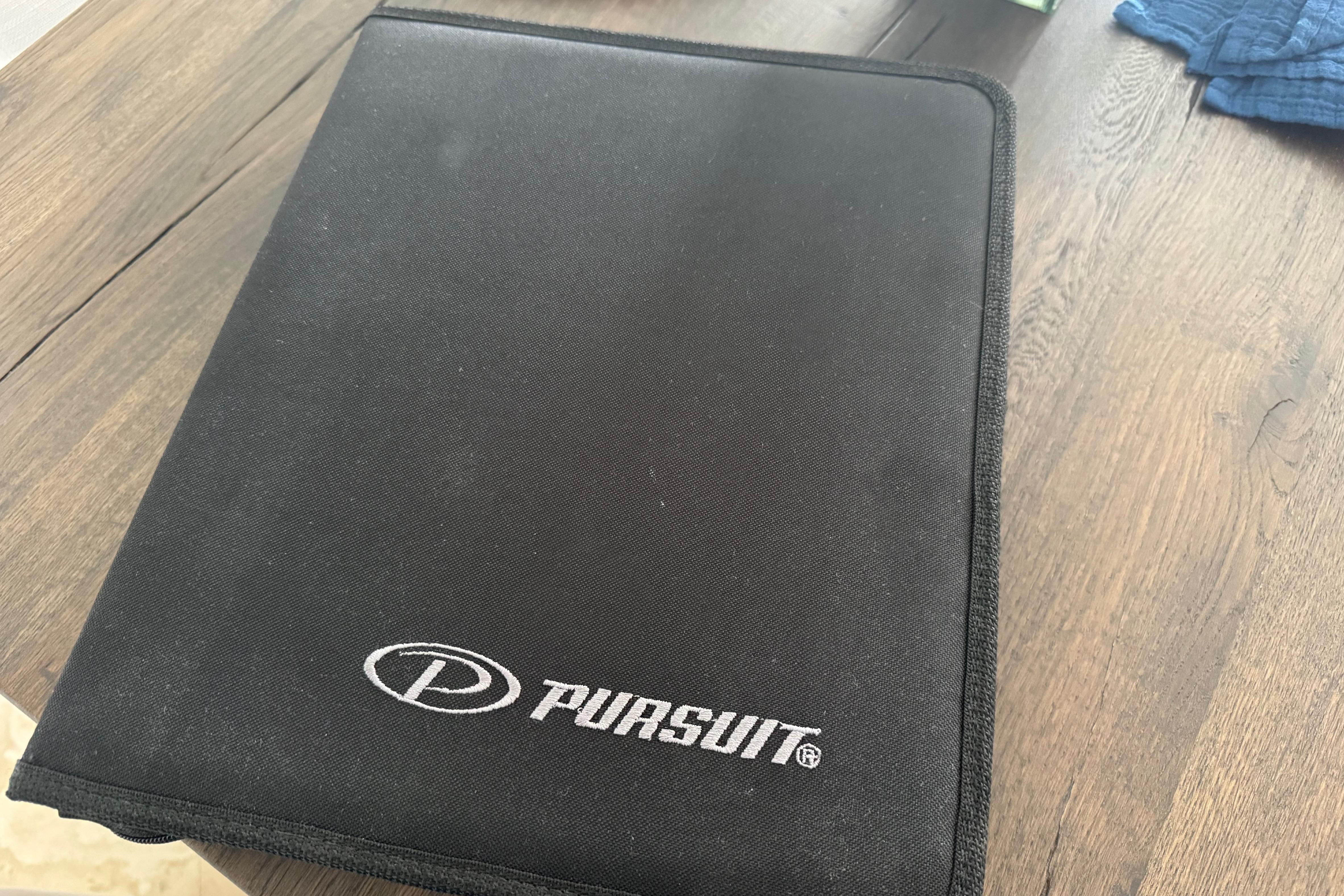 Black Pursuit folder on wooden table, related to 2022 DC 266 Dual Console.