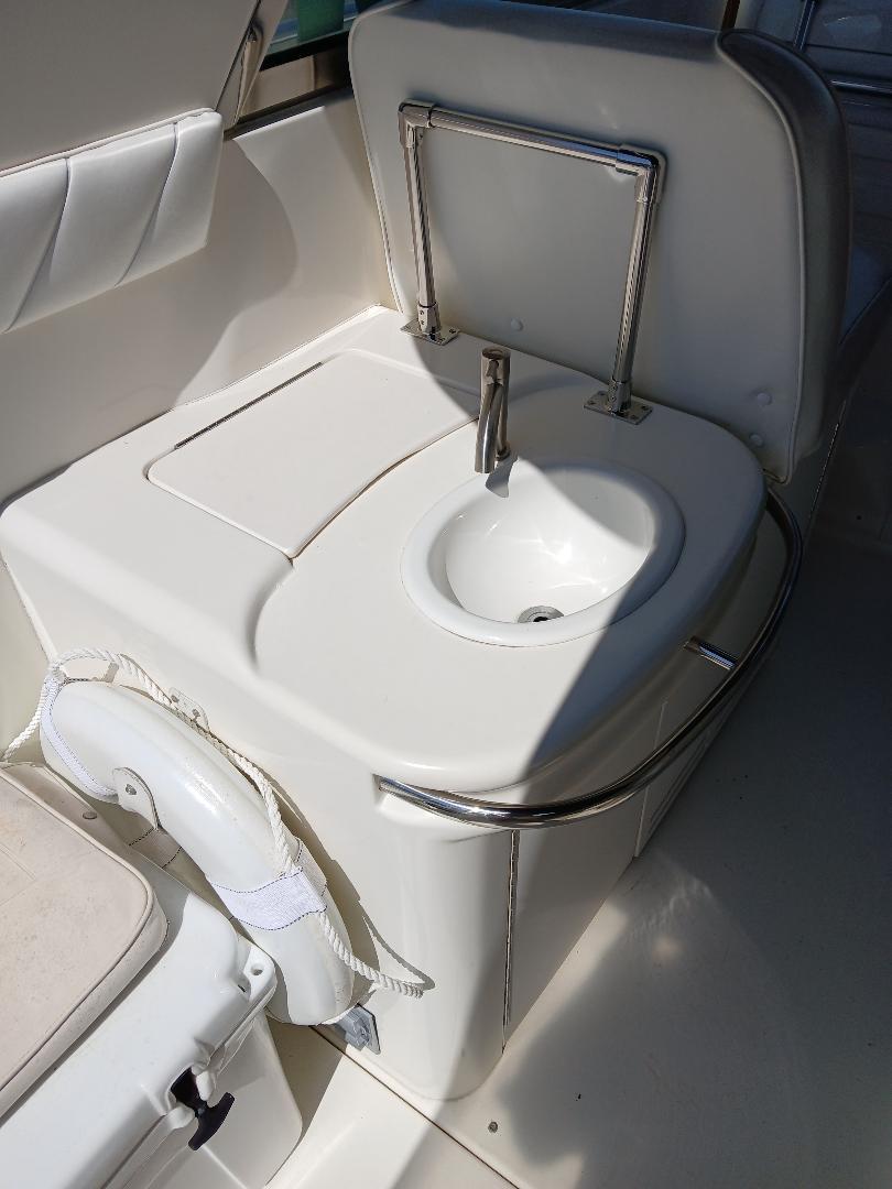 1997 Sea Ray 370 Sundancer boat interior with compact sink and seating area.
